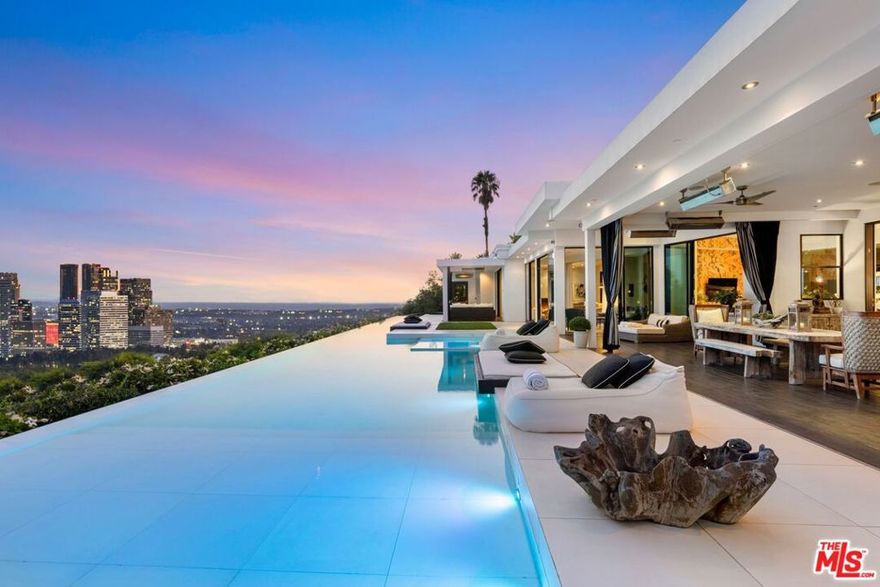 This architectural masterpiece is set upon a promontory on one of the most coveted hidden streets in Beverly Hills, Shadow Hill. One-level Ralph Lauren contemporary with seamless indoor/outdoor living and explosive views from downtown to the ocean and everything in between. Huge deck and an 80-foot swimmers infinity pool with spa that over looks the city. Oversized double-gated motor court. Walls of glass allow natural light to fill the home and frame the endless views. Stainless steel kitchen has an oversized island with seating, a mirrored fireplace, and opens to the deck for dining al fresco. Spacious primary suite with views, a spa-like bathroom, and walk-in closet. The latest and greatest amenities including home theater, office, and a guest house with separate entrance that offers 2BD, a gym, and canyon views. Outside enjoy a built-in BBQ, multiple poolside seating areas with heaters, a fire pit, and outdoor shower overlooking the canyon. Experience unparalleled luxury living in this modern estate, just minutes from the best shopping and dining Beverly Hills has to offer.