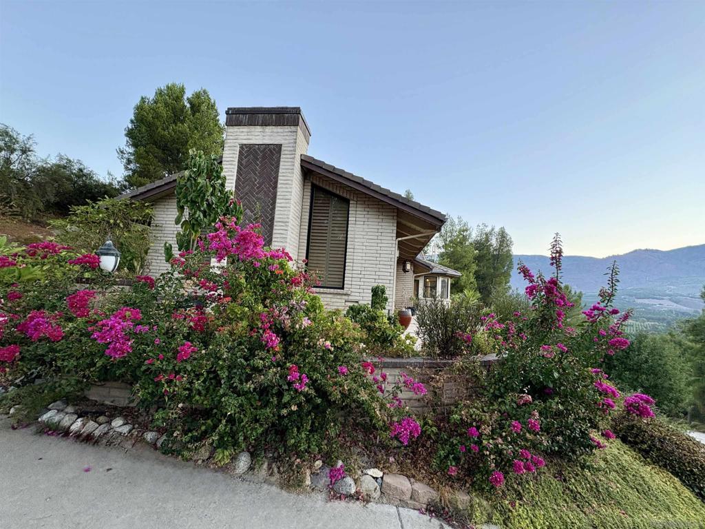 Enjoy the peace and serenity of the Pauma Valley Country Club in this multi-generational home, set high on the hill with gorgeous views of the valley. Wake up to silhouetted mountain sunrises and golf course views! This spacious 4,314 sf 2 story home lives like a ranch estate with vaulted ceilings and expanse living spaces. There are 5 bedrooms, 4 of them are en-suite with an optional room. The open concept chefs kitchen has views to the east with a breakfast nook, 2 deep stainless sinks, walk in pantry, double oven, 5 burner gas stove and 9' by 6' granite slab prep area with counter top seating. The large family room has a wet bar, desk area with built in cabinets and a Franklin stove to warm the area for the cooler winter months. The formal dining has a statement chandelier and stained glass doors. Formal living room has surround windows and sliding glass doors, wood floors and 30 foot ceiling. Primary suite has views, patio access, 2 walk in closets with a hidden room and a closet for hanging clothes. Bathroom has dual sinks, soaking tub and views. Sky lights are in the office, downstairs hallway and stairwell. There are floor to ceiling built-in cabinets in 3 of the en-suite bedrooms, in the wet bar, in the garage and in the laundry room where there is an adjoining cedar lined closet space. The 2 downstairs en suite rooms have sliding glass doors out to the outdoor living spaces. The exterior garden area has been lovingly maintained with 2 Koi ponds complete with water falls and Lilly pads. Owned solar, wine cooler in the 2 car garage plus a separate golf cart garage. This home for sale in the gated Pauma Valley Country Club is set high on the hilltop with gorgeous views of the valley. Wake up to silhouetted mountain sunrises and golf course views! This spacious 4,314 sf 2 story home lives like a ranch style estate with vaulted wood ceilings and spacious living spaces. There are 5 bedrooms, 4 of them are en-suite with an optional room/office/den. The open concept chef's kitchen has views to the valley with a breakfast nook, 2 deep stainless sinks, walk in pantry, double oven, 5 burner gas stove and 9' by 6' granite slab prep area with room for counter top seating. The large family room has views to the east, vaulted ceiling, wet bar, desk area with plenty of storage and a Franklin stove to warm the area for the cooler winter months. The formal dining has a statement chandelier and stained glass doors. Formal living room has wood floors and 30 foot ceiling. Primary suite has views, patio access, 2 walk in closets with a hidden room and another closet for hanging clothes. Bathroom has dual sinks, soaking tub and views. Sky lights are in the office, downstairs hallway and stairwell. There are floor to ceiling built in cabinets in 3 of the en-suite bedrooms, in the wet bar, in the garage and in the laundry room where there is an adjoining cedar lined closet space. The 2 downstairs en suite rooms have sliding glass doors out to the outdoor living spaces. The exterior garden area has been lovingly maintained with 2 Koi ponds complete with water falls and Lilly pads. The Pauma Valley Airpark is located close by for pilots and flying enthusiasts with a 2,700 foot long runway. There is a wine cellar in the 2 car garage plus a separate golf cart garage.