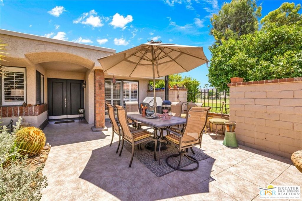 Stunningly remodeled 2 bed, 2 bath home located in the desirable West Gate community, boasting a coveted Palm Springs address and zip code. This exceptional end unit offers privacy with no looming neighbors and sits directly on the Marriott Resort golf course between the 10th and 11th holes.Inside, you'll find soaring vaulted ceilings, smooth coated ceilings, LED recessed lighting with dimmers, and elegant Italian tile floors. The thoughtfully chosen fixtures and lighting throughout the home create a sophisticated ambiance. The guest bathroom has been updated with Italian tile, pebble flooring, quartz countertops, new sinks, fixtures, and a stylish backsplash.The kitchen features a copper farm sink, modern appliances, quartz counters, and plantation shutters throughout. The primary suite includes an updated en-suite bath.This smart home is equipped with a WYSE Home Smart System, tankless water heater, and an upgraded solar system with 18 panels and a 220-amp setup ideal for an EV car charger. Additional upgrades include a garage exhaust fan, insulation on the garage ceiling, and a loft storage area with a pull-down ladder. Land lease has a 10-year extension available for $4,000. Enjoy the best of desert living in a premier location with indoor-outdoor flow and exceptional upgrades throughout.