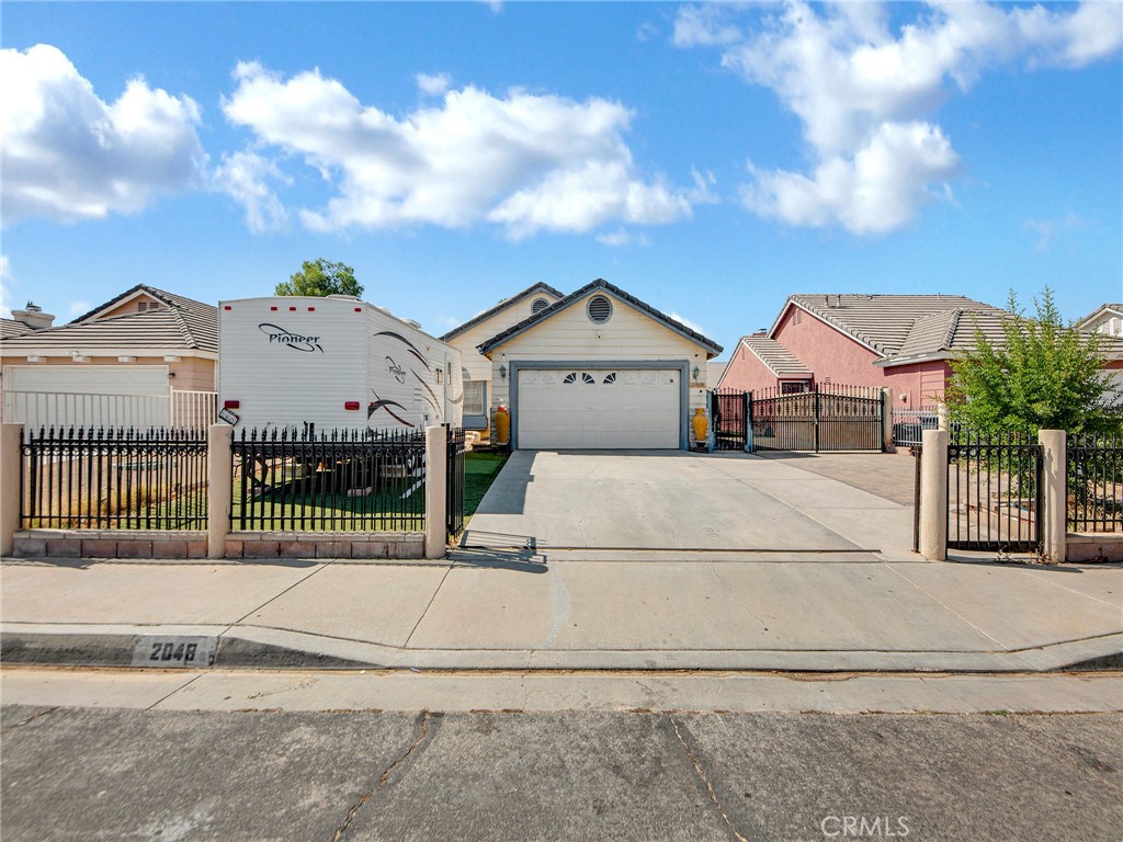 This 4-bedroom, 2-bathroom home spans 1,243 sq ft and includes a back house complete with two bedrooms, one bathroom, a living room area, a fully upgraded kitchen, and a private entrance. Perfect for multigenerational living or as a rental to generate extra income, the back house also has dedicated laundry hookups for added convenience. This home can be occupied as a full house or can be used as two separate units. The residence features a total of four generous bedrooms with laminate wood flooring, a fully remodeled kitchen with high ceilings, an inviting living room with a fireplace, recessed lighting, and an abundance of natural sunlight. The recently built paved side yard with turf adds to the property's low-maintenance appeal, while a separate laundry room enhances functionality. This home also boasts ample parking with room for up to six cars plus an RV, in addition to a 2-car garage that can be converted into an ADU for even more income opportunities. With two security gates for maximum privacy and peace of mind, a dedicated storage unit, and shaded outdoor areas, this home is built for both enjoyment and practicality. Located in a quiet neighborhood with immediate 6-minute access to the 14 freeway, 2048 E Ave R4 offers a rare blend of lifestyle, flexibility, and investment potential—all in one. Centrally located near shopping, restaurants, and grocery stores!