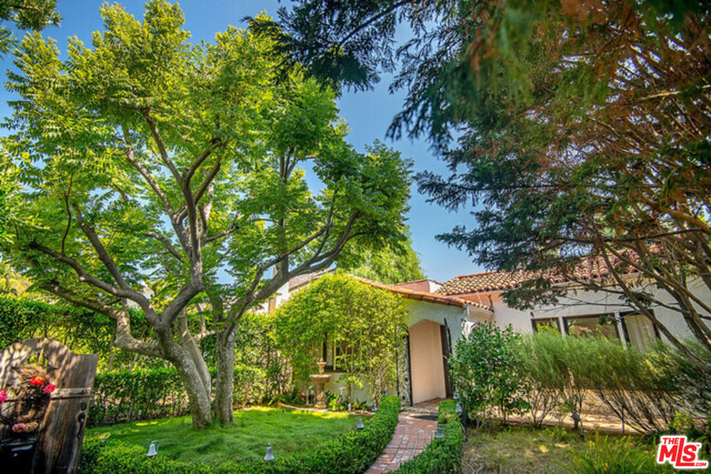 Charming Spanish-Style Home Nestled in a Peaceful Oasis, a truly special home tucked away behind a very private entrance, this warm and inviting Spanish home is rich with character and surrounded by serene greenery. Inside, hardwood floors run throughout, creating a cozy atmosphere that flows seamlessly from room to room. Enjoy a spacious living room, a large formal dining room, and a stunning family room featuring soaring ceilings, stained glass details, and custom built-in bookcases that stretch from floor to ceiling. Abundant natural light pours in through multiple windows, while elegant French doors open to a lush, private yard. The primary suite includes a full bath and opens directly to a tranquil garden adorned with a majestic Coral Tree and a towering Sequoia. A generous office space just off the family room provides the perfect spot for working from home or has the possibility of a third bedroom! Outdoors, the private yard feels like a hidden retreat, offering some of the most breathtaking greenery and mature trees you'll ever see. Pet-friendly and full of charm, this home is truly one-of-a-kind.