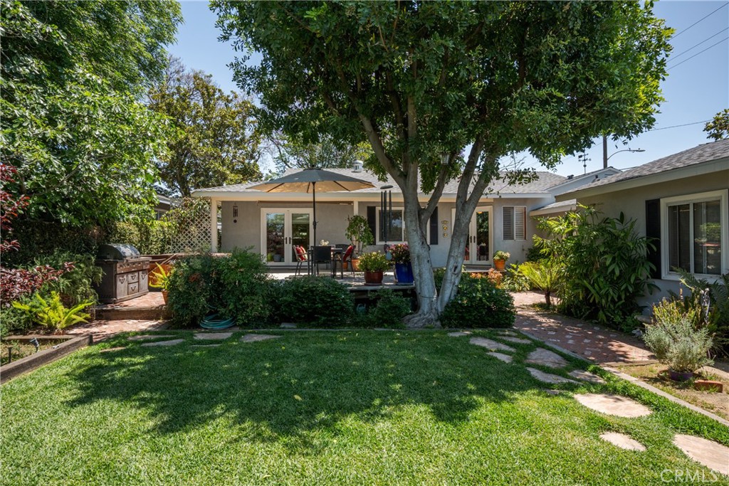 Pride of Ownership! This beautifully updated home offers over 1,900 sq. ft. of inviting living space. Enjoy a spacious formal living room with a cozy fireplace, original hardwood floors, and an updated kitchen with Corian counters, wine fridge, and pantry. French doors open to a professionally landscaped backyard, perfect for entertaining. The step-down den adds extra space and storage. The private primary suite features deck access to a Jacuzzi hot tub, and a luxurious bath with double sinks and a walk-in shower. Additional highlights include a new roof, tankless water heater, electric gate, dedicated generator, plumibing upgrades and more!