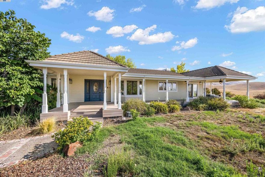 A rare opportunity to own 18+ acres of refined countryside living with commanding 360° views from Livermore’s rolling vineyards to the peaks of Mt. Diablo. Beyond a private tree-lined drive awaits a single-level ranch estate offering 3,400+ sq ft of elegant living. Designed for both grand entertaining and everyday comfort, the home boasts soaring ceilings, expansive living and family rooms each with fireplaces, and walls of glass opening to a wraparound Trex deck showcasing breathtaking panoramas. The gourmet eat-in kitchen anchors the light-filled floor plan, complemented by 3 spacious bedrooms, an office (or optional 4th bedroom), and 2.5 baths. The grounds are equally exceptional, featuring a tennis/pickleball court, 2 horse paddocks, fruit trees, and abundant space for vineyards, olive groves, a barn, arena, or second residence. Additional amenities include a 3-car garage, high-producing well, water storage tank, central AC/heat, central vacuum, and more. Enrolled in The Williamson Act for tax advantages, this estate delivers unmatched privacy, prestige, and possibilities—all within minutes of downtown Livermore, renowned wine country, and premier amenities.