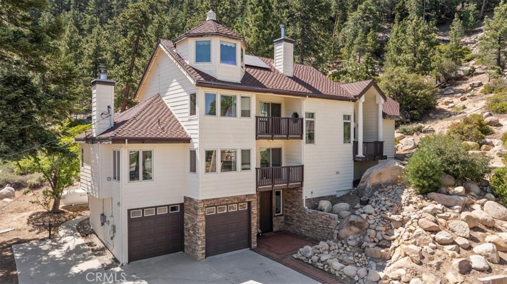 Epic lake views! Located near the dam in a deep-water area of Big Bear Lake, this one-of-a-kind lakeview home offers dock privileges with sandy beach access and some of the most breathtaking views on the mountain. From sunrises and sunsets to moonrises over the lake, every moment here is framed by nature’s beauty. Backing to the National Forest, this peaceful retreat is a haven for outdoor lovers—enjoy fishing, water sports, hiking, biking, and regular sightings of bald eagles, deer, and other local wildlife. A dramatic three-level lighted waterfall welcomes you to a thoughtfully designed, handicap-accessible home featuring a rare five-level elevator. Three spacious private suites each include a full bath; two of the suites also feature kitchenettes. A balcony on each of the three levels offers breathtaking views of the lake and waterfall. At the top, the fourth-floor turret offers sweeping panoramic views and a generous 10’ x 10’ walk-in closet. The main living area is open and airy, with soaring ceilings, a brand-new wood-burning stove, and new stainless steel appliances in the large kitchen—perfect for gathering and entertaining. The primary suite includes a spa-like bath with a Jacuzzi tub and walk-in shower. Additional features include a whole-house reverse osmosis system with a 900-gallon clean water reserve, tankless hot water, owned solar panels, level concrete driveway, full RV hookups, and bonus storage/workshop spaces not included in the square footage. Drawings for main level addition included. Whether you’re seeking a full-time residence, a vacation home, or a income-generating vacation rental, this remarkable lakeside sanctuary in quiet and scenic Fawnskin is a rare opportunity not to be missed.