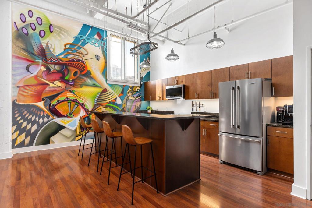 Welcome to the historic Samuel Fox Lofts, a 1929 architectural gem offering the perfect blend of character and modern upgrades. This Mills Act property provides significant tax savings—current property tax is only ~$2,900 annually. Inside, you’ll find an open-concept layout with soaring 16-foot ceilings, natural light from a skylight, and a spacious living and dining area designed for entertaining. The chef’s kitchen features a large island, high-end appliances (all 1–2 years old), and a striking mural by renowned local artist Maxx Moses. This stylish loft includes a walk-in closet, in-unit laundry, and a bathroom with double sinks. Recent upgrades include a new energy-efficient HVAC system (June 2024), ensuring year-round comfort. Building amenities include a rooftop patio with BBQ, seating, and panoramic skyline and sunset views. HOA dues cover gas, trash, sewer, and Google Fiber internet. One deeded underground parking space is included. This unique residence blends history, style, and convenience—offering a rare opportunity to own a piece of San Diego’s past with modern luxury living.