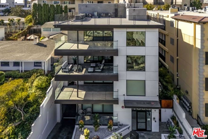 Set within a luxurious four-residence building, this bespoke contemporary home offers nearly 3,000 SF of refined living on its own floor with no shared walls. Guests are welcomed into the residence via a direct-access elevator. The grand, light-filled great room is anchored by wide-plank hardwood floors and expansive glass doors that seamlessly open to a generous terrace with captivating eastern views toward Century City. Designed for both everyday comfort and sophisticated entertaining, the layout includes a spacious living area and a glass-enclosed office. The impressive chef's kitchen boasts professional-grade Wolf appliances, a Sub-Zero refrigerator, dual ovens, a 60-bottle wine fridge, an oversized island with bar seating, and custom cabinetry. A charming dining area sits adjacent, perfect for intimate dinners or festive gatherings. The bedroom wing hosts the stately primary suite featuring a double-sided fireplace, an expansive walk-in closet, and a spa-like bath appointed with floating dual vanities, a freestanding soaking tub, and an oversized glass shower. Additional highlights include a stylish powder room, side-by-side laundry, abundant storage, and dual-zone HVAC. Perfectly positioned moments from the Century City, Beverly Hills dining and boutiques, and world-class golf at LACC and Rancho Park. This move-in-ready residence delivers elevated living at its finest - offering privacy, scale, and style without the upkeep of a single-family home.