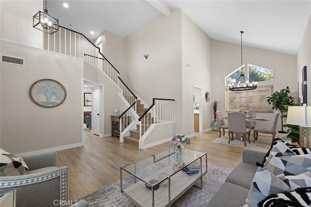 Tucked just off the Green River exit of the 91 Freeway, this thoughtfully updated 3-bedroom, 2.5-bath home offers unbeatable access to Orange County—without the premium price. Vaulted ceilings in the living and dining rooms create a bright, open feel, with sunlight streaming through oversized windows. The home features all-new waterproof flooring, designer lighting, and a reimagined kitchen complete with sleek modern cabinetry, quartz countertops, and a full stainless steel appliance package—including the refrigerator. The family room is centered around a cozy fireplace, and nearby, a separate laundry room and updated half bath add everyday convenience. Upstairs, the spacious primary suite offers an oversized walk-in closet and a beautifully redesigned en-suite bath, while two additional bedrooms—each with generous closets and natural light—share a modernized full bathroom. Freshly painted inside and out, with newer windows and HVAC, this home also includes direct garage access and a private backyard ideal for entertaining or unwinding. Located just minutes from shopping, restaurants, and commuter routes, this is a rare opportunity to enjoy style, space, and convenience in one of Corona’s most desirable locations.
