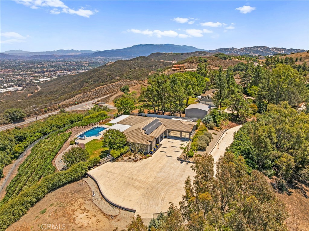 Welcome to Summit Ranch - located on the highly desirable Sycamore Mesa Road. The panoramic views of the Temecula and the De Luz valley are breathtaking. This fully remodeled luxury retreat seamlessly blends modern sophistication with income-producing prestige. From the moment you approach the grand custom steel front door, this property makes a statement of elegance and craftsmanship. The open-concept great room is anchored by a contemporary fireplace and a custom media cabinet that artfully conceals the TV, creating a sleek entertainment experience. The modern chef’s kitchen is a culinary masterpiece, featuring a Wolf double oven with custom ventilation, a full-size dishwasher plus a dedicated stemware dishwasher, a microwave, and a warming drawer. Walls of full-glass collapsible windows frame breathtaking views and allow natural light to flood the space, and are complemented by energy-efficient front windows and bespoke interior and exterior doors. The main suite is a true retreat, boasting an upgraded spa-inspired bathroom and a spacious walk-in closet, while the powder room reflects an equally refined design. Outdoors, the remodeled pool overlooks the property’s boutique vineyard, planted with Syrah and Cabernet grapes, while the thriving avocado grove with 450 trees offers additional income potential. With PAID solar, this estate not only embodies luxury but also efficiency and sustainability. Perfectly situated near Old Town Temecula and a scenic drive from renowned wineries, Summit Ranch is a rare opportunity to enjoy a lifestyle of modern elegance, stunning views, and multiple streams of income, all in the heart of Temecula Valley. This could be your new home or your next wonderful investment!