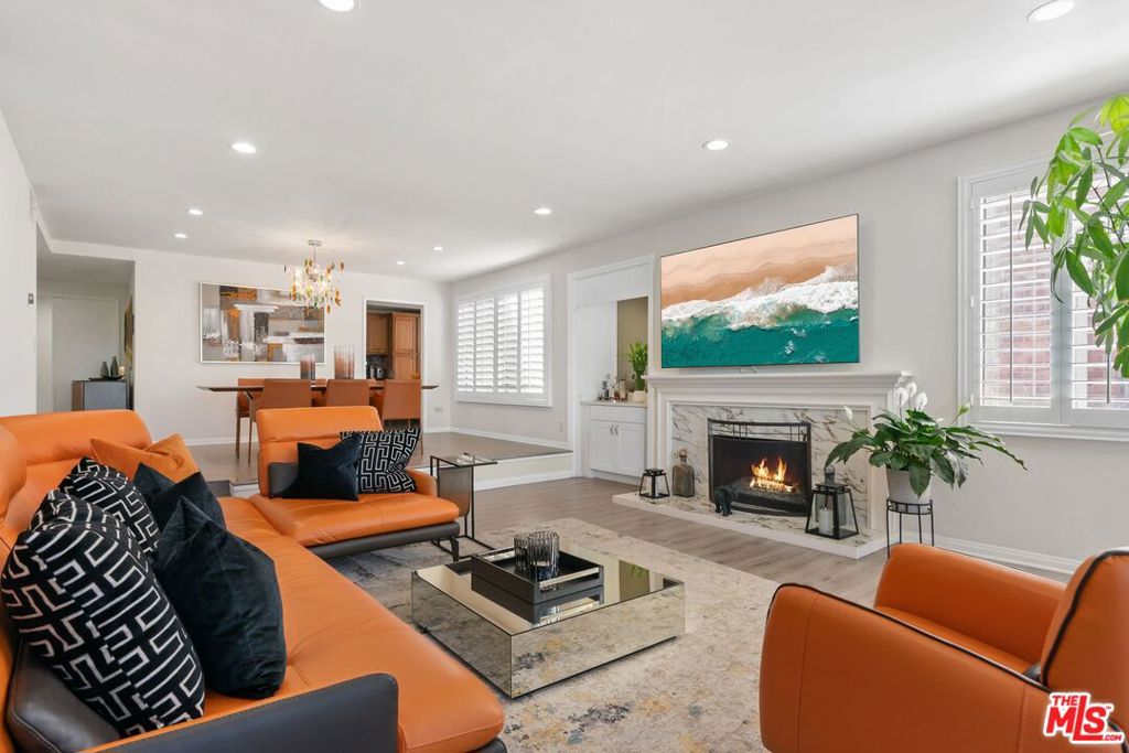 Experience the best of Encino living in this elegant, light-filled corner residence at the highly sought-after Horton Lane complex. Perfectly positioned across from Balboa Park Sports Complex, Encino Golf Course, and the scenic trails of Lake Balboa, this expansive 2-bedroom, 2-bath condo offers over 1,700 square feet of sophisticated single-level living with sweeping views from the park to the mountains. Step inside to a thoughtfully designed open layout featuring a sunken living room with a cozy fireplace and seamless access to two private balconies ideal for morning coffee or evening entertaining. The updated kitchen boasts granite countertops, custom cabinetry, slate flooring, and stainless steel appliances, while the adjoining dining area and wet bar provide an inviting setting for gatherings. The oversized primary suite is a true retreat, complete with dual closets including a generous walk-in closet and a beautifully remodeled spa-inspired bath with double vanities and direct balcony access. The junior suite offers equal comfort with its own updated bath, and an in-unit side-by-side washer and dryer adds everyday convenience. Additional features include renovated laminate flooring, recessed LED lighting, dual-pane windows, central HVAC, and abundant storage throughout. Secure gated parking includes two tandem spaces and a private storage locker. Residents also enjoy complex amenities: a sparkling pool and spa and peaceful walking paths surrounded by lush landscaping. With unbeatable proximity to Trader Joe's, top-rated recreation; Golf courses, tennis/pickleball courts and convenient freeway access, this home blends luxury, comfort, and location making it a rare find in the heart of Encino!