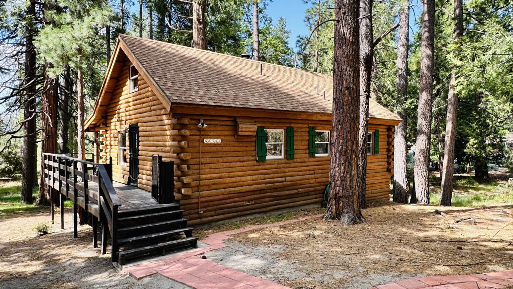 Lovely Log. Nestled at the edge of a tranquil meadow, among towering pines and cedars, this romantic Log Cabin is reminiscent of yesteryear. 2 Bedrooms, 1 full bath the ultimate mountain retreat. The spacious wraparound decks, partially covered for year-round enjoyment, is a perfect place to watch deer wandering through the grassland along the nearby meandering seasonal creek. Inside, an open-concept living area features a focal point, cozy wood-burning stove for winter nights. The primary bedroom faces the peaceful meadow, while the second bedroom includes laundry hookups in a closet for added convenience. A sturdy ladder leads to a bonus loft space, perfect for a potential creative retreat, guest quarters or just storage. Recent upgrades include a newer tankless water heater and brand new septic leach lines (2024), ensuring comfort and peace of mind. Whether you're seeking a full-time escape or a weekend haven, this inviting log cabin blends rustic charm, modern updates, and flexible living space in a truly idyllic setting.