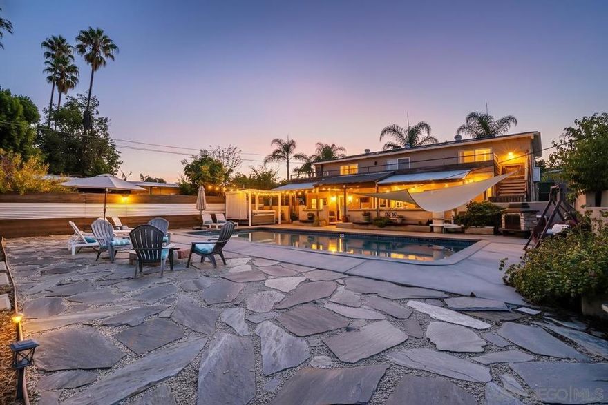 This beautifully updated two-story residence offers a spacious and inviting atmosphere. The open-concept kitchen features sleek countertops and modern cabinetry, seamlessly connecting to the dining and family rooms, ideal for both everyday living and entertaining. Large windows throughout the home allow for an abundance of natural light, creating a bright and airy ambiance. The private master suite boasts a walk-in closet and an ensuite bathroom for added comfort. Downstairs, a separate living area with a kitchenette, den, and two bedrooms provides flexibility for guests or extended family. Step outside to the beautifully remodeled patio and pool area, complete with seating areas, an outdoor fireplace, and a firepit, perfect for gatherings and relaxation.