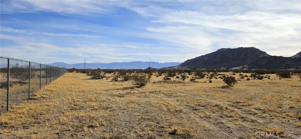 Discover the potential of this 3.65-acre parcel with excellent access right off Highway 247. Power is conveniently located across the street, making development that much easier. The level, buildable terrain offers endless possibilities for your dream home, investment property, or other ventures. The property features chain-link fencing and boasts stunning mountain views that create the perfect backdrop for your project. Conveniently located just a short drive from the center of town, this parcel combines accessibility, natural beauty, and opportunity. Don’t miss out on this chance to own a piece of the high desert with prime frontage and plenty of potential! (APN: 0453-231-01-0000).