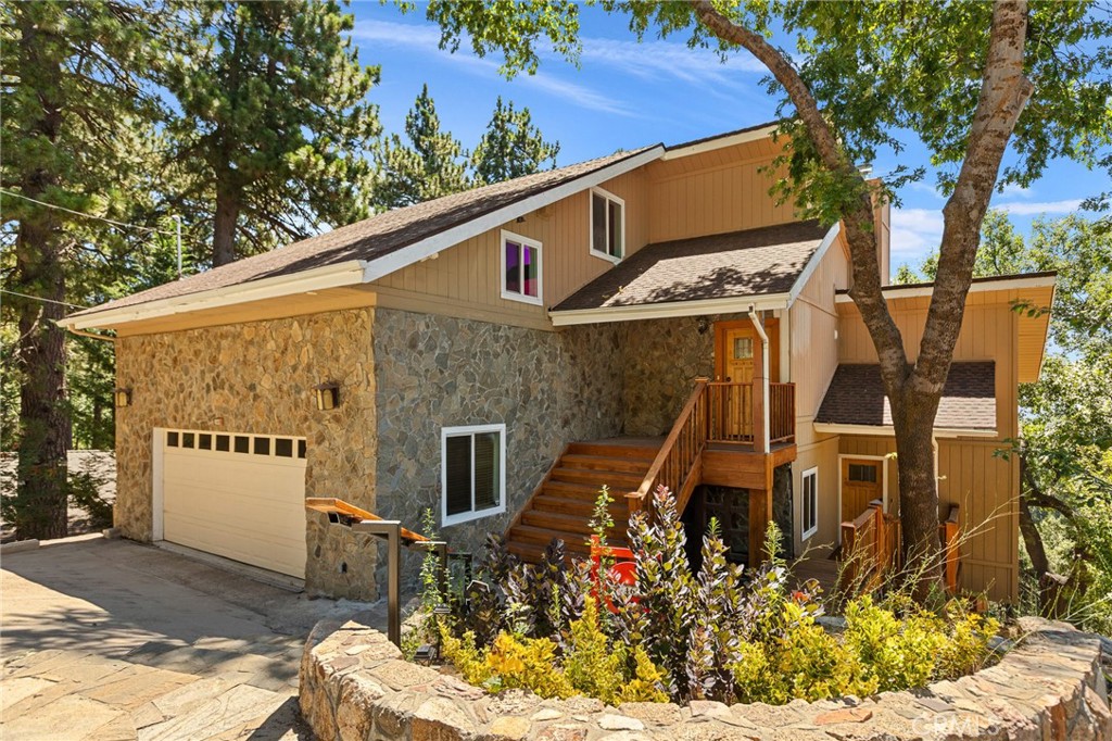Hugged by treetops sweeping views of the Valley & forested ridgelines sits a one-of-a-kind mountain home that brings comfort, creativity & connection together. From the moment you enter, this custom-built retreat reveals its magic. Soaring ceilings, warm cherry wood floors & the glow of two fireplaces welcome you in, while two full kitchens, dual entrances & multiple private living spaces offer unmatched flexibility perfect for hosting extended family, accommodating guests, or creating multi-generational harmony under one roof, not to mention investment potential with 3 possible rental units. The primary suite feels like a luxury resort—unwind in the programmable Kohler rainfall walk through shower, enjoy spa-like tile floors underfoot & choose between your custom his-and-hers walk-in closets & bathrooms. Just steps away, find your personal theater, private lounge & a flexible room ideal for a home office, nursery or meditation space. The bonus artist loft, framed by skylights & natural light, radiates happy energy & inspires creativity. On the lower level, guests will enjoy a private retreat with its own living room, kitchen, deck & fireplace, plus two bedrooms & two baths. This space connects to the main home or can serve as a separate rental thanks to its private entrance perfect for additional income or extended stays. Recent upgrades to this light & bright home include dual-zone central A/C & heat, new gas fireplace inserts, a customizable home generator, Alexa-enabled thermostats, new water heater, ceiling fans & a fully reinforced lower deck supporting a 7-person Bluetooth-enabled spa the perfect place to sip wine as the sun sets over the valley lights. Ever experienced snowfall while soaking in a spa? Another magical mountain favorite you won’t forget. The setting: no neighbors behind you just 15 acres of quiet, undeveloped land teeming with wildlife, deer, birds & the peaceful hum of nature. Friendly full-time & part-time neighbors form a true mountain community, complete with summer block parties, shared resources & neighborhood group texts. The street is unusually wide, allowing ample parking & easy year-round access. Whether you’re lounging in a hammock watching hummingbirds dance, working from one of two home offices, or enjoying cozy family movie nights by the fire, this home isn’t just spacious it’s soulful. Just a quick drive to Snow Valley, Sky Park, hiking trails, the town farmers market & the 330 Hwy. Adventure awaits.