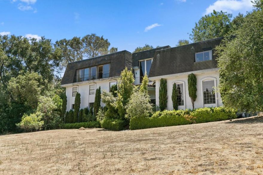 Nestled in the sought-after hills near Los Altos Country Club, this French Country Chateau offers 5,172 sq ft of thoughtfully designed living space set on a generous 1+acre lot.With 4 bedrooms, 3 full and 2 half baths, and two primary suites - including a main suite with an expansive bathroom, dual vanities, and a spacious walk-in closet..theres room for everyone.The custom office with built-in bookshelves easily converts to a 5th bedroom, while a large bonus room is ready to become your ideal media room, gym, or creative studio.Inside, youll find soaring ceilings in the formal living room, a welcoming fireplace, wet bar, and views stretching toward the San Mateo Bridge. Other highlights include a formal dining room with coffered ceilings, an open family room, eat-in kitchen leading to a private patio, indoor laundry with built-in cabinetry, and a 4-car tandem garage with extra-tall doors, workshop, mezzanine storage, and additional space for oversized vehicles.While the home awaits your vision and updates, the expansive lot provides endless possibilities..a rare opportunity for a future SB9 lot split, guesthouse, or ADU? With its timeless architecture and exceptional potential, this property is the perfect canvas to create your dream estate, just minutes from downtown Los Altos.