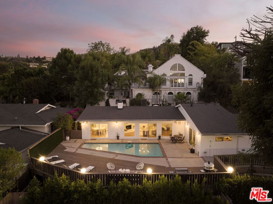 South of the Boulevard and tucked discreetly behind private gates, this nearly 2,200 sq ft reimagined mid-century residence unfolds across a private hillside setting where natural light, quiet luxury, and effortless indooroutdoor flow define everyday living. The double-door entry opens to soaring vaulted wood-beam ceilings, wide-plank oak floors, and skylights that wash the space in soft daylight. Walls of glass frame the sparkling pool and expansive deck beyond, blurring the line between indoors and out. A complete 2019 remodel transformed the home, creating seamless flow between the living, dining, and chef's kitchen; a masterclass in design finished with a waterfall island, custom walnut cabinetry, Miele and Viking appliances, Italian terrazzo flooring, and brass accents that bring warmth and modern sophistication in equal measure. The primary suite is a private sanctuary with direct pool access, a large walk-in closet, and a spa-worthy bath wrapped in Fireclay tile, dual showers, a Restoration Hardware vanity, and curated finishes that exude understated luxury. The secondary wing includes two additional bedrooms, a full guest bath, and a powder room just off the living area, ideal for hosting and everyday ease. A pocket door provides quiet separation when desired. Outside, resort-style living unfolds in a completely private backyard framed by lush hedges and freshly refinished decking. The resurfaced pool glows beneath sunset skies, paired with brand-new, energy-efficient heating and filtration systems. Multiple lounging and dining zones invite relaxation from morning yoga to evening cocktails. The setting is remarkably serene  no street noise, no nearby distractions, just birdsong by day and the soft call of a resident owl by night. Every detail reflects thoughtful craftsmanship and care: a full laundry room, soaring 12-foot ceilings, integrated Sonos sound, new HVAC, all-new windows and glass sliders, a new tankless water heater, and abundant custom storage throughout. Exterior enhancements include a new roof, freshly sealed garage, upgraded drainage and irrigation systems, mature privacy hedges, and complete property security with Ring entry and cameras. Private and gated driveway is shared. Set on one of Sherman Oaks' most coveted stretches of Valley Vista, just moments from Ventura Boulevard's premier restaurants, cafes, and boutiques, zoned for a top-rated charter elementary, and with a nearly private hiking trail right across the street, this gated retreat offers a rare blend of tranquility, convenience, and architectural grace. Timeless mid-century soul meets modern refinement, wrapped in that unmistakable California magic. ***14823 Valley Vista Blvd is also available for sale to make a fully private gated compound. Contact Zach Krasman for more info***