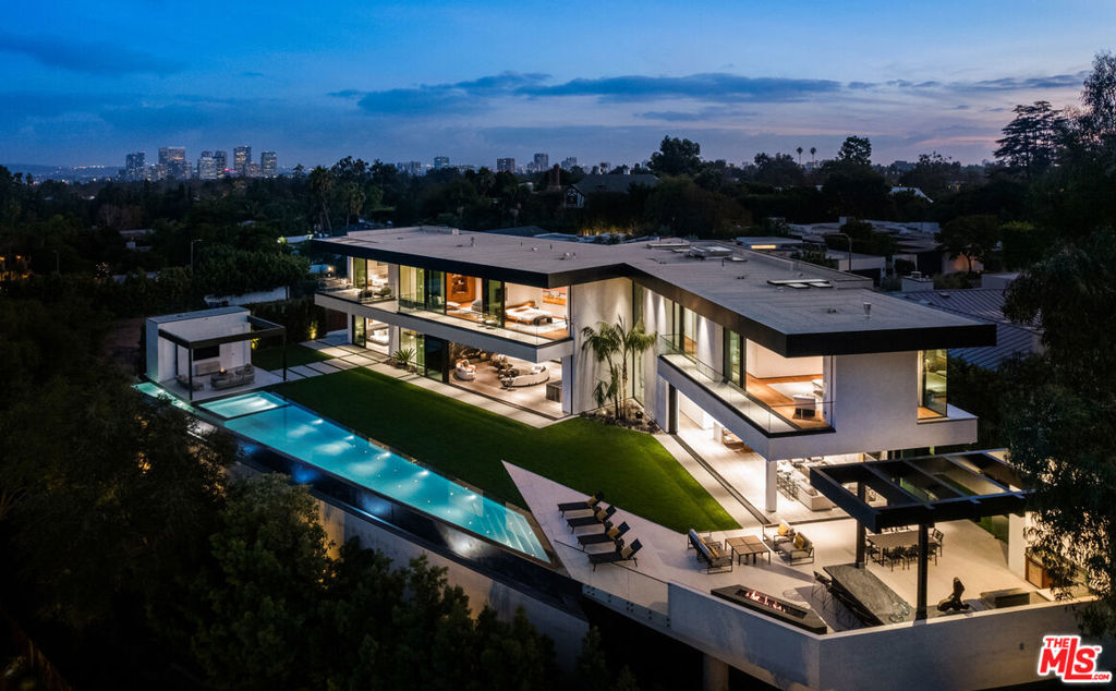 Stunning 2022 new construction property set in the most desirable zip code in the world! An impressive collaboration between Iconic x Paul McLean creates a one-of-a-kind, warm and organic architectural gem, leaving no details spared. Showcasing sweeping views of Downtown and Century City, this ~10,400sf masterpiece features 5 bedrooms with an option for 6, 10 bathrooms and the most stellar amenities. An inviting Zen entryway welcomes you into the open-concept living space with soaring ceilings and amazing natural light penetrating the floor-to-ceiling glass doors throughout. The main level includes a spacious formal living room, spectacular wet bar with wine fridges, formal dining space, and a glamorous gourmet chef's kitchen with white bespoke cabinetry, top-of-the-line Miele and Subzero appliances. An entertainer's dream, from the kitchen and family room, glass doors open revealing the generous backyard hosting a full outdoor kitchen with ample seating and fire pit, a pool cabana, and an 80-foot zero edge infinity pool with a jacuzzi that seats up to 20 people. Unparalleled design and exquisite finishes throughout, the primary bedroom is a showstopper with a stunning stone fireplace, an attached deck overlooking the grounds, showroom style walk-in closets with custom walnut cabinetry, and bathroom with double shower and beautiful freestanding soaking tub. Additional features include a daylit gym with a stone waterfall, an alluring spa with sauna, steam shower and massage room, as well as a theater, climate-controlled wine cellar, and an office with a separate entry. Complete with Creston control, Lutron lighting and shades, and parking for 4-cars, this property is truly unrivaled!