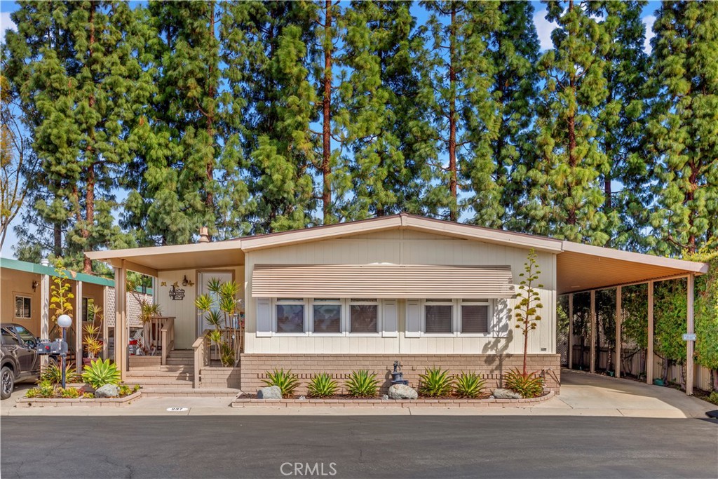 No Space Rent Here! This is your chance to own both a beautiful 2 bed, 2 bath home and a share in the Corporation that owns the land! Welcome to The Groves, an inviting, vibrant 55+ community nestled in the heart of Irvine. Step into this light and bright home, featuring an updated kitchen that is open to the family room which has direct access to a spacious enclosed covered porch. The seamless flowing floor plan is ideal for entertaining with the added bonus of a separate living and dining room. The spacious primary bedroom comes complete with a walk-in closet, and the primary bathroom boasts a large walk-in shower and dual sinks. With its warm durable flooring, crisp white paint, and the Vermont Cast-iron fireplace provides warm and a cozy feel. Plus, the refrigerator, washer, and dryer are included for your convenience. Parking is a breeze with a carport that fits 2 cars and a houses a spacious storage unit. Unwind in the evenings on the front porch with your favorite beverage while enjoying the sunset. The Groves has a wealth of incredible amenities to enjoy, including a heated pool & spa, gym, sauna, tennis, pickleball & basketball courts, a putting green, lawn bowling, and community BBQs with outdoor seating. The clubhouse is the heart of the community, with banquet facilities, a game room, a hair salon, and card rooms. For creative enthusiasts, you'll find a ceramic studio, a wood-shop, and a lovely garden area to explore. There’s also designated RV parking and a camping club! With on-site management and an activities coordinator, the community is buzzing with events, clubs, and opportunities to connect with neighbors and make new friends. The low monthly maintenance fees and discounted Cox TV and Internet make living here even more attractive. Come see how The Groves offers the perfect blend of comfort, community, and fun—your new home awaits!