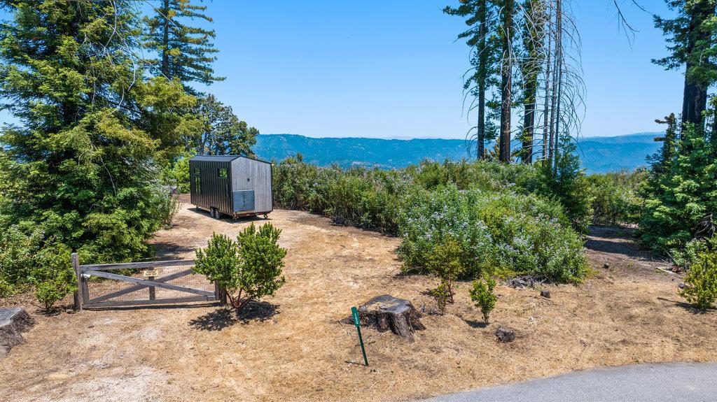 Nestled in the serene Braemoor Estates, 150 Braemoor Drive offers a rare opportunity to build your dream home on this sunny 3.28-acre lot. This expansive property captures the essence of tranquil living with breathtaking panoramic views and abundant sunshine. Above the fog-line, this parcel offers an unparalleled vista and a sense of community with a shared appreciation for the natural beauty of the area. Whether you envision a sleek modern design or a cozy mountain retreat, this property could be the canvas for your vision. Previously home to a residence, the lot has been cleared of debris and ash following the CZU fire. It has passed soil sample tests, had level 2 erosion control completed, and is approved for obtaining a rebuilding permit per Santa Cruz County. There are existing septic and well systems that were inspected and in working order prior to the home being lost; the current condition of these systems is unknown. There is currently a tiny home onsite, which can be negotiated as part of the sale.