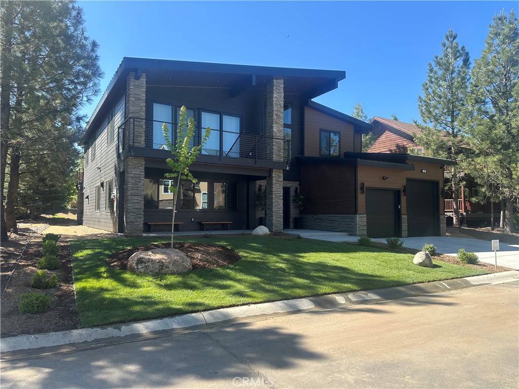 DISCOVER THE ULTIMATE RETREAT IN THIS BRAND NEW RUSTIC CONTEMPORARY HOME, COMPLETE WITH MODERN AMENITIES, SITUATED IN THE EXCLUSIVE GATED COMMUNITY OF EAGLES KNOLL ~ Conveniently located to all that Big Bear has to offer, this home is across the street from the lake and the community offers a private marina, common tennis court, and community park ~ Quality construction and well-designed open floor plan w/ loads of upgrades including air conditioning & smart home controls ~ The upscale kitchen is a chef's delight, equipped w/ high end Decor appliances (fridge, stove, dishwasher, range, microwave & wine dispenser) & a spacious center island for entertaining ~ The adjacent dining area creates a perfect setting for intimate meals ~ Step outside through the large folding doors, allowing the crisp mountain air to flow throughout the home, bringing the outdoors in, hosting gatherings, & enjoying the built-in bbq w/ friends & family ~ The expansive living room features tall ceilings & a gas fireplace, creating a cozy yet spacious ambiance ~ The large game room upstairs, complete w/ a bar & massive sliding glass door, provides an additional space for entertainment & relaxation ~ Fire sprinklers included for added safety & energy-saving solar panels (leased) ~ Level entry oversized 2-car garage, featuring electrical wiring for EV charging, tall ceilings, & a garage door suitable for boat storage ~ Come view this beautiful home!