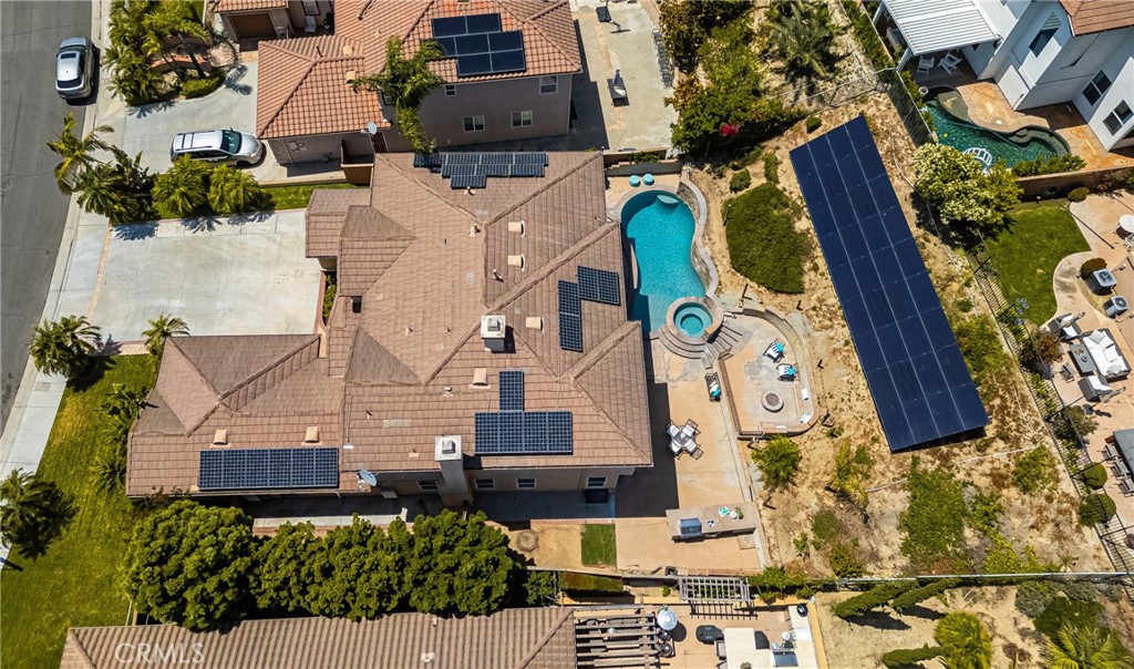 Welcome to your dream retreat in Serrano Heights Estates! Nestled on a quiet cul-de-sac, this elegant 5-bedroom, 3-bath home blends comfort and luxury across 3,620 SF of living space. From the moment you step inside, you're greeted by soaring ceilings, a sweeping staircase, and rich laminate floors that create a warm, welcoming feel. The gourmet kitchen—complete with granite island, stainless steel appliances, and generous storage—opens to a cozy breakfast nook and spacious family room with a fireplace. French doors lead to a private backyard paradise featuring a saltwater pebble tec pool and spa, rock waterfalls, built-in BBQ, and an elevated patio with fire pit. A main-floor bedroom and full bath provide the perfect setup for multigenerational living or overnight guests. Upstairs, the expansive primary suite offers a spa-style bath and dual walk-in closets, while a converted loft adds a 6th bedroom for extra flexibility.