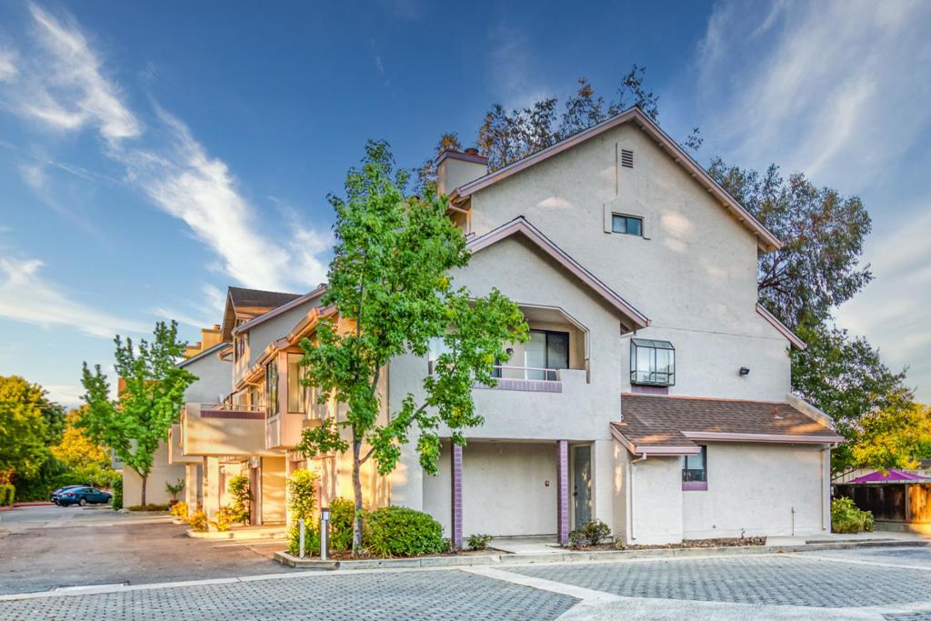 Price Reduced! PRIVACY AT THE HEART OF MIDTOWN | Tucked away within a highly desired community, this end-unit home combines peace, privacy, and easy access to world-class amenities. Inside, the sky-lit, breezy layout boasts soaring vaulted ceilings, a fireplace, and open living and dining areas that flow into a private balcony. One bedroom and full bath are located on the main level, while a private entrance connects to a bedroom and full bath on the upper level. Also included are a flexible third bedroom/office, detached garage, assigned parking, and convenient upper-level laundry. Within strolling distance are Hoover and Seale Parks, Safeway, YMCA, Philz, Walgreens, and much more. Enjoy living just moments from shopping and dining along California Avenue, Caltrain, Stanford, tech companies, and top-ranking schools like El Carmelo Elementary, JLS Middle, and Palo Alto High (buyer to verify attendance).