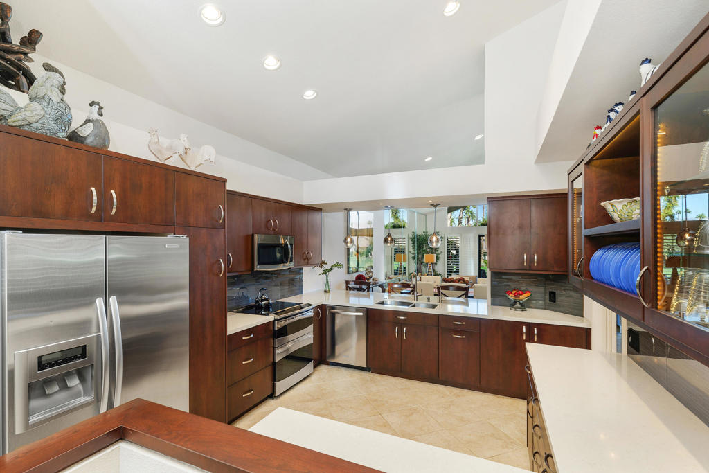 You won't want to miss this impeccably maintained, highly upgraded two-bedroom + Den, three-bathroom Dallas model.   High vaulted ceilings with transom windows creates an open and airy atmosphere, with golf course views easily enjoyed from the main living areas. The open floorplan of almost 2,300 SqFt features two primary bedrooms, with a den that could be easily converted to a third bedroom.  Floor to ceiling decor lighting creates a warm ambiance to highlight the custom millwork.  Loads of seating with front and back patios.  Expansive upper and lower conversation areas, showcase the mountain and distant water feature views from the golf course patio off the living room.  While the sunny, tiled front courtyard is a private outdoor entertaining space, complete with built-in BBQ.  There is direct access to the garage from the front courtyard and the house.  The upgraded finishings extend into the oversized 2 car + golf cart garage with built in cabinets.  This home comes TURNKEY FURNISHED with designer furnishings, allowing for a seamless move-in experience. Golf cart included!! The Lakes Country Club offers several dining options, 27 holes of golf, tennis, pickleball and 44 swimming pools located conveniently throughout the private guard-gated community.