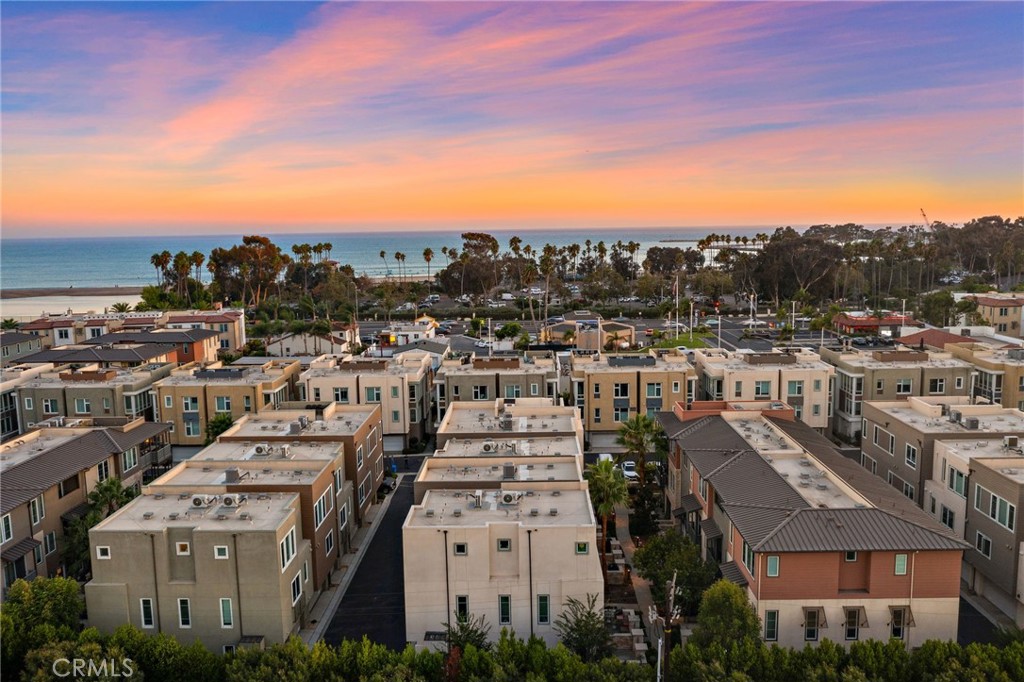 Welcome to South Cove, Dana Point’s premier coastal community just steps from Doheny State Beach. This stunning 2-bedroom, 2.5-bathroom home offers over 1,500 sq. ft. of thoughtfully designed living space and a rare 3-car tandem garage with plenty of storage. The open-concept main level features a bright kitchen with modern finishes, spacious dining area, and living room that opens to a private covered balcony through LaCantina doors—perfect for enjoying ocean breezes. Upstairs, both bedrooms include en-suite baths for privacy and comfort, with a beautifully appointed primary suite and walk-in closet. Additional highlights include energy-efficient windows, inside laundry, and access to community amenities including a resort-style pool and spa. Just a short walk to Dana Point Harbor—currently undergoing a $600 million revitalization set to make it a premier Southern California destination by 2027—plus dining, shopping, and world-class beaches, this home is ideal as a primary residence, vacation getaway, or income-producing property with 30-day rental eligibility. Experience the perfect blend of laid-back luxury and coastal convenience.