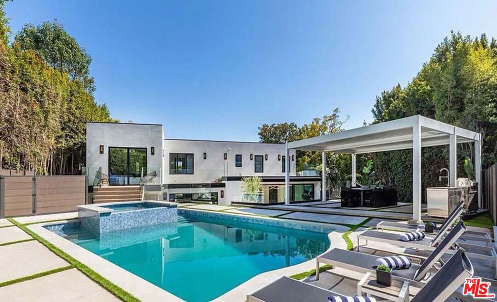 Welcome to this exquisite gated residence located just above the Sunset Strip, where luxury and design blend seamlessly to create a stunning living experience. Natural wide plank oak floors flow throughout the open-concept layout, setting the tone for the home's warm and inviting aesthetic. The massive kitchen is a chef's dream, featuring top-of-the-line Miele appliances, a custom zinc-finished hood, elegant marble countertops, and a striking custom brown rounded island, perfect for those who love to entertain. The home's attention to detail continues with a custom chevron floor landing that highlights the staircase, complemented by a vintage-inspired 1940s iron railing, adding a timeless touch to the modern elegance of the space. The primary suite is a serene escape, featuring two large walk-in closets, a cozy seating area, and its own private staircase leading directly to the pool and spa for seamless indoor-outdoor living. Each bedroom boasts its own private patio, creating personal sanctuaries for every member of the household. Outside you will find a large pool and spa complemented by an alfresco dining area beneath a stunning automatic pergola. The outdoor fire pit and spacious patios provide additional areas for lounging and gathering. Thoughtfully designed lighting enhances the space, creating a captivating ambiance for evening gatherings. The expansive, private backyard offers ample room for relaxation, while one of the balconies reveals sweeping city views, adding to the allure of this exceptional outdoor oasis. Additional features include a gated driveway that accommodates up to five cars, a two-car garage, and the convenience of being minutes away from the iconic Sunset Plaza.