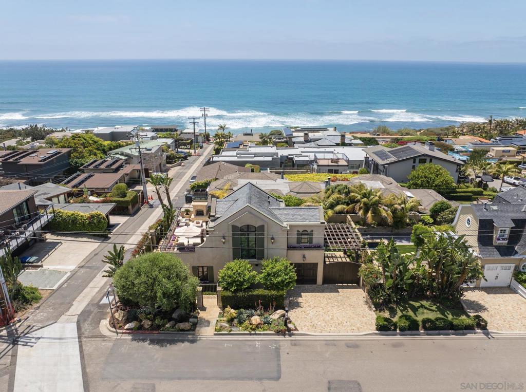 With sweeping ocean views that stretch beyond La Jolla, this elegant tri-level villa offers 3 bedrooms, 3.5 bathrooms, and a converted one-car garage transformed into a cozy, heated flex space—ideal for a home office or guest room, complete with a fold-out Murphy bed. Step through ultra-private, gated stone and stucco entrances into a warm Tuscan-inspired retreat. The interior is rich with character, featuring handcrafted tile, distressed Hickory wood floors, and exposed wood ceiling beams. The main level is an entertainer’s dream, with a spacious great room that seamlessly connects the gourmet kitchen, living, family, and dining areas. Framed by custom windows and French doors, the space is constantly filled with ocean breezes, the soft sound of waves, and abundant natural light. The kitchen blends beauty with function, offering large island counters with prep sinks, bar seating, and stylish cabinetry with ample storage. Elegant touches like recessed and chandelier lighting, a custom fireplace, and a luxurious powder room complete this floor. Upstairs, the primary suite is a private sanctuary with a massive sun deck boasting panoramic views, an outdoor fireplace, and generous lounging space. The spa-like en-suite bath features a double vanity, walk-in glass shower with mosaic marble tile, a juliet balcony, and custom windows framing Pacific Ocean views. A spacious walk-in closet with built-ins and natural light completes the space. The lower level—despite being partially below grade—feels bright and welcoming. It includes two bedrooms, two bathrooms, a large media room The lower level—despite being partially below grade—feels bright and welcoming. It includes two bedrooms, two bathrooms, a large media room, wet bar, and a full-size laundry room with extensive cabinetry and counter space. Step out to the home's private backyard where you’ll find a lush California dreamscape; new green grass lawn with stepping stone pavers, manicured landscaping, a charming pool, and multiple semi-covered seating areas. Overhead heaters, built-in BBQ kitchen, and a boutique-hotel vibe make this the perfect setting for alfresco dining or laid-back lounging. Located just moments from Powerhouse Park, The Del Mar Plaza, The Del Mar Racetrack, Torrey Pines, and top-rated schools—with the beach and dog park just steps away—this home offers a rare blend of refined living and relaxed coastal lifestyle. Your new memories, your new lifestyle, and your new address awaits. Welcome home.