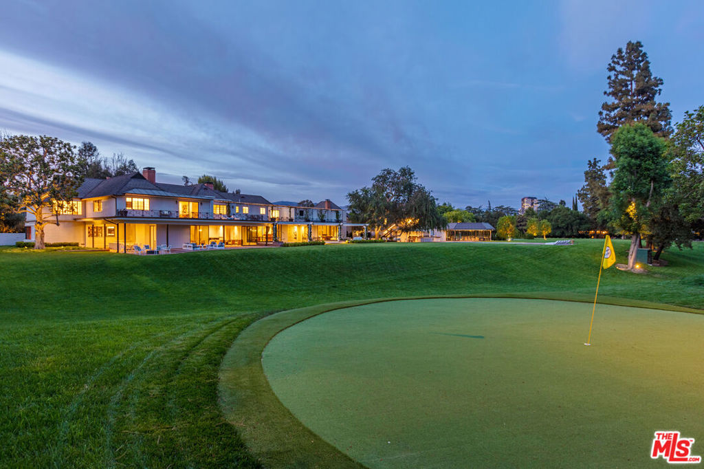 A celebrity legacy residence, The Bob Hope Estate is the jewel of Toluca Lake, offering gracious amenities, an expansive outdoor oasis, and gorgeous, well-preserved architectural elements by John Elgin Woolf, the father of the Hollywood Regency style. With six bedrooms in the main home - in addition to the two staff bedrooms and two-bedroom apartment - and 17 total bathrooms, The Hope estate presents tranquil indoor-outdoor living surrounded by pristine beauty and privacy. Inside, wide plank White Oak hardwood floors glisten, with each detail carefully curated to respect the homes original elegance. Walls of glass look out onto the lush greenery, while stone accents add natural textures. The open living area includes a stone-clad fireplace - one of six fireplaces in the home - leading to a large dining area that offers ample space for dinner parties. Hope's original oak library has been meticulously preserved, while high-end fixtures and finishes - from the Waterworks fixtures to the white Carrera marble bathroom counters and floors - elevate the residence with thoughtful care. The extensive private outdoor terraces provide peaceful retreats and lend perfectly to entertaining. Impeccable landscape design by Art Luna presents an extensively restored oasis. The grounds abound with outdoor amenities, including a saltwater pool, lounge areas to relax with guests, a one-hole golf course designed by Hope himself with two tee positions, a tennis court, and a large barbecue kitchen. Tall, mature trees surround, providing an ultra-private paradise, and mountains can be seen in the distance. Opportunities to luxuriate are ample within the estate; enjoy a home theater and a gym with a steam and infrared sauna. A four-car garage, motor court, extensive security system, security office, and three electric gate entrances provide turn-key convenience. An ancillary structure containing a tennis pavilion, commercial kitchen, security office, conference room, original walk-in fireproof safe, and Hope's personal office has also been meticulously restored, featuring convenient visitor parking outside. The property contains an additional two-bedroom apartment above the garage, along with staff quarters in the courtyard off of the main house. Restaurants, shopping, and private aviation are moments away, providing a life of ease and comfort. Elegant and timeless, this estate offers a treasure trove of history, style, and luxurious Los Angeles living.