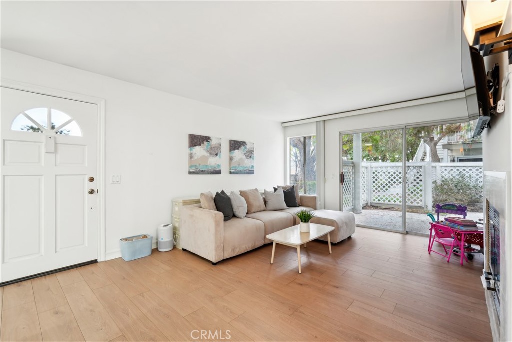 FHA Approved! Welcome to this charming lower-level 2-bedroom, 2-bathroom condo. Thoughtfully updated and move-in ready, this inviting home offers a light and airy feel with tasteful finishes throughout. Step into a spacious living room featuring beautiful wood-style flooring, a cozy gas fireplace, and large sliding glass doors that open to your private patio—perfect for morning coffee or weekend relaxing. The open layout flows effortlessly into the dining area and kitchen, creating a comfortable space for everyday living and entertaining. The kitchen boasts white cabinetry, neutral countertops, and stainless steel appliances including a dishwasher and built-in microwave. Recessed lighting adds a modern touch while a breakfast bar opens to the dining nook, offering both style and convenience. The primary bedroom includes an en-suite bathroom and generous closet space, while the second bedroom is perfect for guests, a home office, or growing families. Both bathrooms are updated with fresh, clean finishes and modern vanities. This unit has also been upgraded with new plumbing, providing peace of mind and added value for years to come. Additional highlights include central air and heat, two covered carport spaces, and access to community amenities. The complex is FHA approved, making financing more accessible for many buyers. Enjoy a well-maintained community with lush landscaping, all conveniently located near shopping, dining, parks, and easy freeway access. Whether you're a first-time buyer, downsizing, or seeking a smart investment, this condo checks all the boxes!