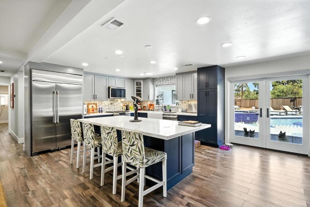 Welcome to your dream home! Nestled on an oversized 14,810 sq ft lot, this beautiful single-family residence offers 4 spacious bedrooms, 3.5 bathrooms, and 2,125 sq ft of living space. Inside, you're greeted by warm wood flooring and a bright, open living area perfect for family gatherings and entertaining. The heart of the home is the modern kitchen, featuring two-toned cabinetry, stainless steel appliances, ample storage, and a large island counter ideal for meal prep or casual dining. Glass doors off the kitchen lead to your backyard retreat, seamlessly blending indoor-outdoor living. Discover generously sized bedrooms, including a luxurious primary suite with a walk-in closet and an ensuite bathroom. Step outside to your private backyard oasis complete with a heated pool, hot tub, waterslide, outdoor sound system, and patio, all designed for unforgettable summer fun. A separate entrance to the yard ensures privacy and convenience, while RV parking with its own rear access adds versatility. Additional highlights include a commercial-grade solar system and plenty of room to entertain or relax under the sun or stars. This home is the perfect blend of comfort, functionality, and resort-style living. Dont miss your chance to own this incredible property!