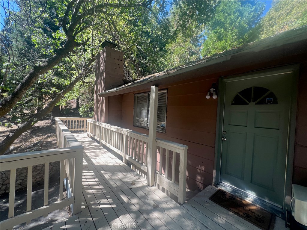 Escape to the mountains in this cozy and versatile 3 bedroom 1.5 bath two-story cabin, perfectly located in the desirable Lower Rowco area of Running Springs. Just minutes from local ski resorts, hiking trails, and year-round outdoor adventure, this home offers the ideal balance of rustic charm and everyday comfort. Step onto the welcoming top-level deck, then enter into a warm and inviting living room with a wood-burning fireplace, seamlessly connected to the dining area — perfect for gatherings and quiet evenings alike. The main floor features a bedroom with an electric fireplace, a full bathroom, and a functional kitchen with direct access to the backyard for easy indoor-outdoor living. Downstairs, you’ll find two additional bedrooms, each with their own electric fireplace, a half bath, and a laundry room with a storage area — great for gear, tools, or seasonal items. Additional features include a carport and off-street parking, offering convenience and flexibility year-round. Whether you're looking for a full-time residence, weekend getaway, or rental opportunity, this mountain retreat is ready for your personal touch.