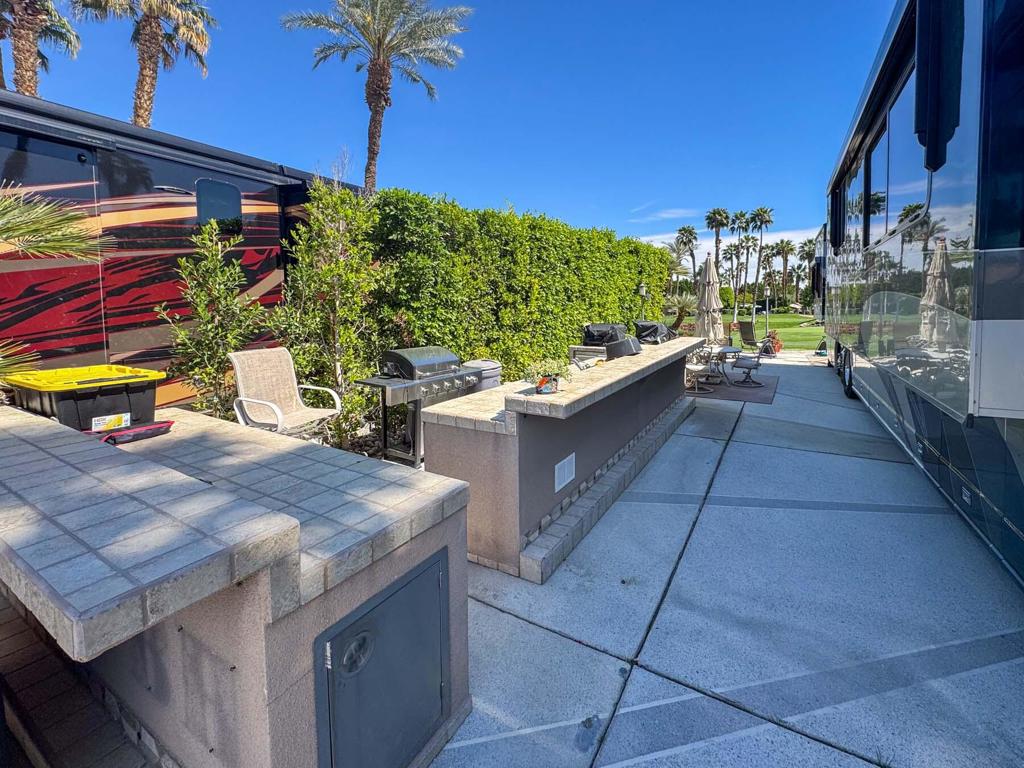 This luxury RV lot boasts a spacious outdoor kitchen with a built-in bar, extra island, and breathtaking golf course views, offering the perfect blend of elegance and functionality for elevated resort living. Situated in a prime location, this private lot features a coated RV pad and an extended paver patio, providing ample space for relaxation and entertainment. The outdoor kitchen is equipped with stainless appliances, making it ideal for hosting gatherings or enjoying quiet evenings with a view. Thoughtfully designed for both comfort and style, this lot offers an exclusive retreat within the prestigious Outdoor Resort Indio. Plus, it's conveniently located just across the street from the laundry, satellite pool, hot tub, sauna, and resort facilities, ensuring easy access to top-tier amenities in this premier RV community. Some furnishings included.‍Outdoor Resort Indio is a Class A only RV resort in Indio, CA.