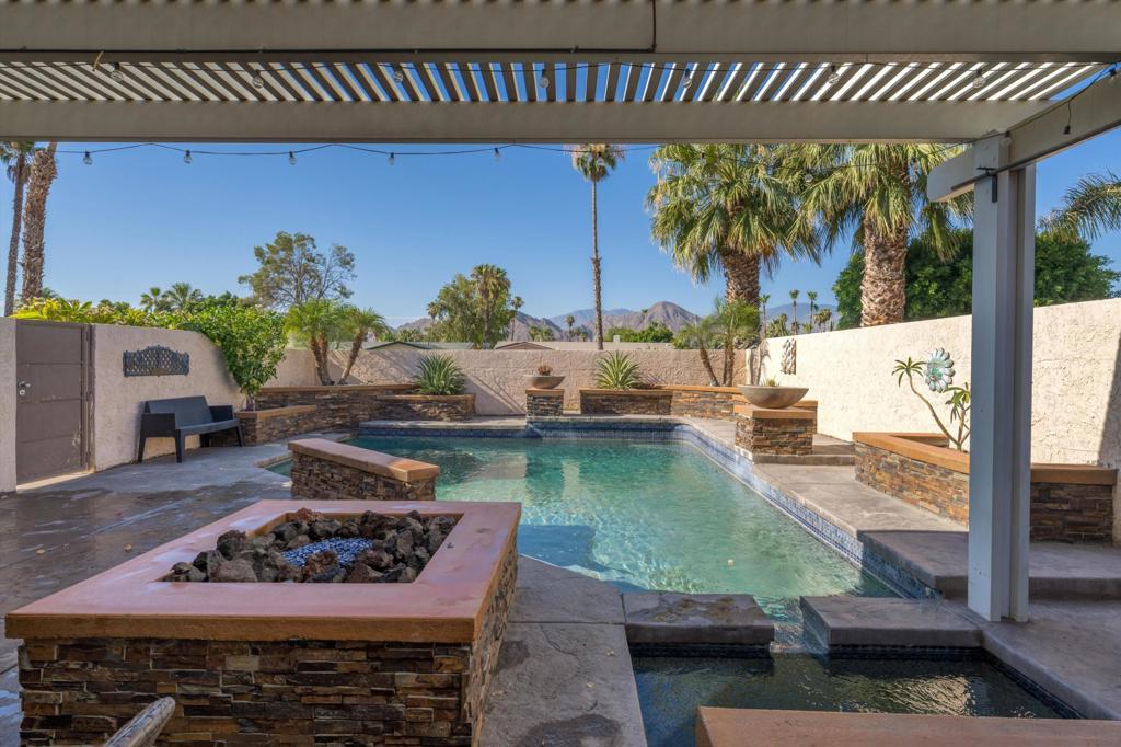 The main photo says it all- Welcome to this charming 3 bed 2 bath 1400+ sq foot single family home in the desirable non gated community of Palm Desert Country Club community. From your private, gated pool area, enjoy spectacular southern mountain views while relaxing by the built in fire pit, sunken spa or under the covered seating area on the stamped concrete patio.As you move toward the main entrance you will find a cozy outdoor dining space with convienent pass through to kitchen. Inside the living room highlighted by vaulted ceiling, full stone fireplace, oversized patio doors that open directly to the pool perfectly framing those breathtaking southern mountain views. Kitchen has been updated w/ SS appliances, granite counters & ample cabinets. Garage access comes right into the kitchen. Primary bedroom features en suite bath and private patio door leading to the back yard. The 3rd bedroom is a versatile space, also with patio access, ideal for a guest room, office, or hobby area. The spacious back yard is enhanced with a new paver patio providing even more outdoor space.Palm Desert CC Golf course is just down the street and your minutes from world-famous Indian Wells Tennis Gargen home to the BNP Paribas Tennis tournament. Shopping, groceries, access to Interstate 10 or the new Acrisure Arena, home to the Coachella Valley Firebird AHL hockey team is all just a short drive away.