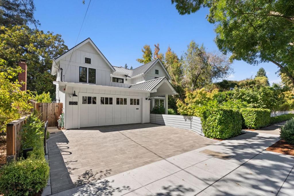 This modern entertainer's dream home showcases thoughtful designs and boasts 3,693 square feet of living space, five bedrooms, an office, four and one-half bathrooms, and an open floor plan ideal for modern living. Enjoy entertaining in the formal living and dining rooms featuring designer finishes, built-in curtains, a cozy fireplace with a stone mantle and gas insert, and designer light fixtures, or cooking your favorite meals in the gourmet kitchen boasting Carrara marble countertops, flushed inset cabinetry, Thermador appliances, a beverage fridge, walk-in pantry, and a service window from the built-in barbecue. The great room boasts a serene backyard view, a second fireplace with a stone mantle and gas insert, surround sound speakers, and expansive windows for natural light. The upstairs living area features three en-suite bedrooms with vaulted ceilings, including a large primary bedroom with a massive walk-in closet, a luxurious shower, a marble bathtub, and dual vanity sinks. A balcony and a convenient laundry room with a washer and dryer complete the upstairs. The basement offers bonus spaces, including a game/media room with full kitchenette including two additional bedrooms, one ideal for an exercise studio or home office and another with its own bathroom.