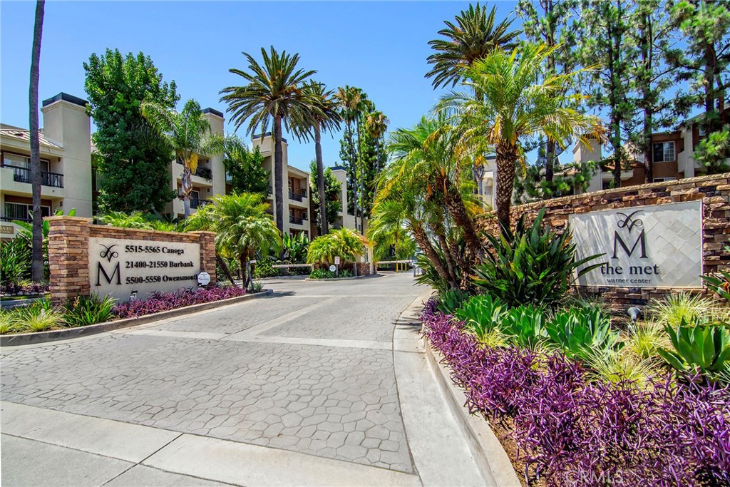 Resort style living in the heart of Warner Center, welcome to The Met! Immaculate 2 Bed + 2 Bath condo located on the 1st floor of building #3. Turn key unit tucked away at the back of the building, walking distance to the main pool, gym & tennis courts. Certainly the most desirable floor plan, this style utilizes an open concept with a guest bedroom and full bath up front, while the master sits at the back of the unit with views of the exterior! The master bedroom also offers a luxurious en suite bathroom featuring double vanity sinks in addition to an enormous closet. This spacious and beautiful condo features such amenities as wood style flooring throughout (NO CARPET), gas fireplace, granite countertops & stainless steel appliances. Designated dining room for more formal eating yet with open views to the living area and outdoor space. The living room has been extended by the original builder to allow for a larger living area, while still providing inspiring views of the rear grounds. Last but not least, your very own WASHER & DRYER IN THE UNIT + 2 COVERED parking spaces in the garage below!!! The Met is a guard gated community that offers 4 resort-style swimming pools, six night lighted tennis courts, full fitness center, racquetball, indoor basketball court, multiple spas & 24 hour guard gated security. All this located within walking distance to The Village, Warner Center Park and all the dining, shopping & entertainment Warner Center has to offer.