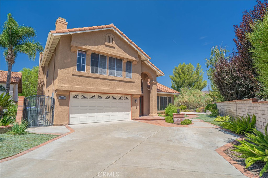 Spacious Verbena Model in Bouquet Canyon Estates. Tucked at the end of a quiet cul-de-sac in the sought-after Bouquet Canyon Estates community of Saugus, this expansive two-story home offers privacy, mountain views, and a highly desirable floor plan. This popular Verbena plan features 4 bedrooms plus a large loft/bonus room, including a full bedroom and bathroom on the main level perfect for guests or multigenerational living. Inside, you’ll find separate living and family rooms, a formal dining room, and a remodeled kitchen with upgraded cabinetry, granite counters, an island, updated appliances, and crown molding. The kitchen opens to the cozy family room, complete with a wet bar, brick fireplace, and custom built-in oak cabinetry. The primary suite offers a spacious retreat with mountain views, walk-in closet, and a remodeled en suite bath featuring granite counters, tile flooring, updated cabinetry, a soaking tub, and a frameless glass shower. Upstairs, the generous loft/bonus room boasts oak built-ins, a desk area, and an additional fireplace. Distressed hardwood floors flow through the entry, living room, formal dining room, and kitchen for a warm, timeless feel. Step outside to your oversized private backyard, complete with a cozy covered patio, fire pit, and panoramic mountain views—ideal for entertaining or quiet evenings at home. Additional highlights include a 6.3 kW solar system, copper plumbing, and a prime location close to parks, schools, and amenities.