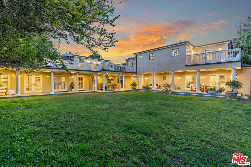 Exquisitely Renovated Mediterranean Estate in Windsor Square. Welcome to this timeless yet modern 5-bedroom, 5.5-bath Mediterranean retreat, thoughtfully reimagined through a down-to-the-studs renovation and two-story addition. Nestled in the heart of historic Windsor Square, just moments from the charm of Larchmont, this gated estate offers 15,311 sq. ft. of lush, private grounds and a lifestyle of understated elegance and comfort. Enter through a gracious foyer into sun-drenched living spaces that blend original architectural character with contemporary sophistication. A double-sided fireplace anchors the formal living room and courtyard, while the expansive chef's kitchen and family lounge open to a courtyard perfect for peaceful meditation or vibrant entertaining. The gourmet kitchen, with high ceilings, is a chef's dream, featuring premium appliances, custom cabinetry, storage, wine and beverage refrigerators and a large island ideal for gatherings. The formal dining room and multiple lounging areas provide space for both grand-scale entertaining and intimate family life. Two spacious bedrooms are located on the main level, including one of two luxurious primary suites. Upstairs, discover three additional en-suite bedrooms, including the second primary suite with a balcony. Designed with privacy in mind, the home features balconies off multiple rooms, a serene courtyard, and generous indoor-outdoor flow. The landscaped backyard includes a covered loggia, outdoor kitchen, and alfresco dining are a perfect for entertaining or relaxing in your secluded oasis, with room for a pool! Additional amenities include a separate office/guest suite with full bath above the garage, a spacious ADU with full kitchen, alarm system, LifeSource water system, ample off-street parking including several guest spaces, and a 2 car garage. This property is gated, private, and situated on a gentle hill among mature trees and fruit trees offering rare tranquility in the city. Located within the Third Street School District and minutes from world-class dining, shopping, vibrant Larchmont Village, The Ebell, and LACMA, this contemporary Mediterranean residence offers the best of Los Angeles living.