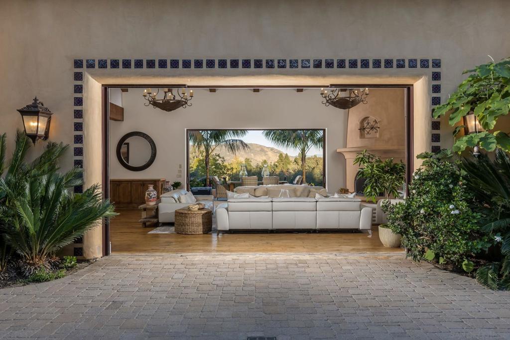 Prepare to be mesmerized by the charm, the A+ Rancho Santa Fe Covenant location, the 4 meticulously landscaped acres, and the magical panoramic VIEWS of the surrounding mountain ranges. The timeless architectural detail of the estate accurately reflects the “Rancho” vibe with Spanish influences throughout – soaring beamed ceilings, arched passageways, custom painted tile add a sense of grandeur and luxury to the home. The property features 5 generous Br suites. The primary is a true sanctuary, highlighted by an adjacent relaxation retreat and a picturesque courtyard to enjoy morning coffee. The family room and kitchen are designed with entertaining in mind, boasting top-of-the-line appliances, leather-finished slab stone island, temperature-controlled wine cellar, enhanced by two large sliding doors which fully disappear into the walls on both sides of the room to make the courtyard and patio all part of an expansive living room experience for year-round dining and socializing. The detached guest house, with its own private gated entry, offers a secluded retreat for hosting family and friends, while the entire property is fully fenced and gated, ensuring complete privacy and exclusivity. The estate’s outdoor amenities are equally enchanting, including a beautifully remodeled pool and spa, fireplace w/cozy seating area, meandering garden paths to explore, lovely courtyards, and ample room to add equestrian facilities or sporting pursuits including tennis, pickleball, golf practice range/green, making this property an idyllic sanctuary to enjoy privacy, peace and tranquility. All this yet so close to the village, Roger Rowe, Rancho Santa Fe Golf Club and a short drive to the beach and downtown San Diego!