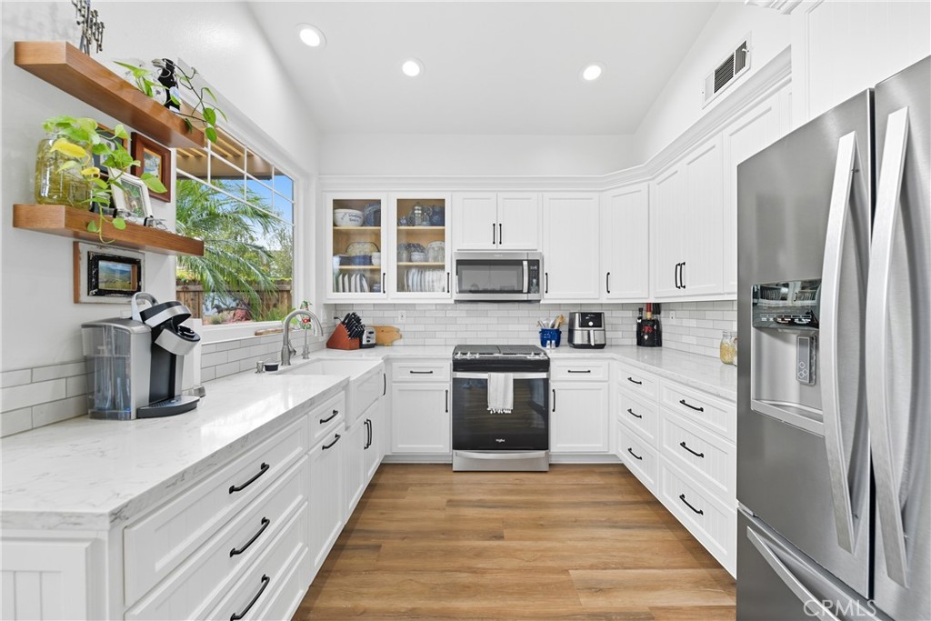 Welcome to this beautifully upgraded and impeccably maintained 3-bedroom, 2-bathroom located in the highly desirable Mission Oaks area in Ventana community. Boasting true pride of ownership, this single-story gem offers 1,325 square feet of thoughtfully designed living space. Walk through the inviting double-door entry into a freshly painted interior featuring stunning new luxury vinyl plank flooring throughout. The spacious living room welcomes you with tall ceilings, a cozy gas fireplace, transom window for added natural light, and an open yet defined layout that flows seamlessly into the bright and airy dining room. Enjoy abundant sunlight from multiple windows and a brand-new sliding glass door that opens directly to the backyard oasis. The fully remodeled kitchen is a showstopper, complete with crisp white cabinetry with soft-close drawers and doors, quartz countertops, a farmhouse sink, stainless steel appliances, and a tall pantry with convenient pull-out drawers—perfect for both everyday living and entertaining. The spacious primary suite is ideally situated off the living room and features tall ceilings, generous closet space, and a new sliding glass door leading to the private backyard. The ensuite bathroom has a walk-in shower and has been beautifully updated with a new white vanity, quartz countertops, updated fixtures, and modern flooring. Two additional bedrooms—currently used as a home office and craft room—also feature new paint and flooring. A tastefully updated hall bathroom serves these rooms and adds to the home's appeal. Step outside to your low-maintenance backyard retreat, showcasing lush landscaping, artificial turf, a large patio cover, and mature foliage that creates a private and serene setting. HOA amenities include pool & spa, gated RV parking (subject to availability), and front yard landscaping. Don’t miss this opportunity to own a turnkey home in one of Camarillo’s most desirable communities!