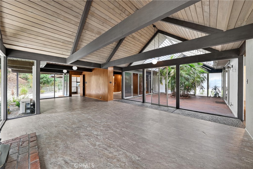 Step into iconic California living with this beautifully preserved mid-century modern home, thoughtfully designed by famed architects A. Quincy Jones and Frederick Emmons. This expansive five-bedroom residence celebrates light, space, and design with its signature open-beam ceilings, walls of glass, and seamless connection to nature. At the heart of the home lies a tranquil private atrium — an ideal setting for morning coffee, quiet reflection, or evening gatherings. The primary suite opens to a lush, park-like backyard that extends the living space outdoors, perfect for relaxation or entertaining under the California sky. Positioned at the end of a peaceful cul-de-sac on an oversized lot with no rear neighbor, the property offers a rare sense of privacy and retreat. Experience the timeless sophistication of mid-century modern living — where thoughtful architecture and natural beauty create a lifestyle that feels both refined and restorative.