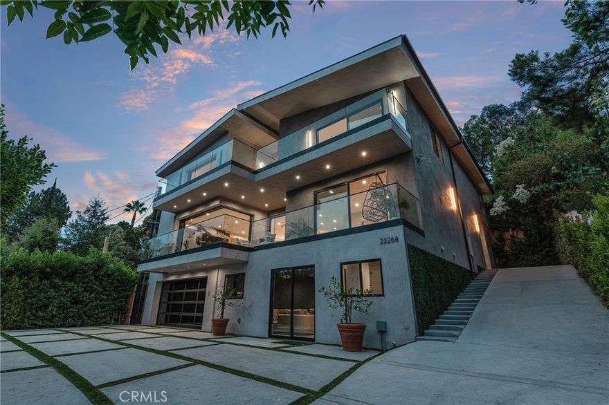 Gated modern estate newly constructed in 2024 with just completed brand new pool & spa located South of the Boulevard with Valley, mountain, & city light views! Privately tucked away and hidden from the street, the property is situated down a long gated driveway with pedestrian access and flanked by tall growth hedging. Oversized parking can accommodate 10 cars plus there is direct access to an extra deep 540 SF 2-car garage. The interiors boast meticulous craftsmanship, designer finishes, and almost every room looks out to gorgeous views. A glass pivot entry door opens to a grand foyer where you’ll find a completely open floor plan filled with natural light from sweeping glass doors that open to the vistas beyond. The chef’s gourmet kitchen boasts massive center island with breakfast bar seating, stainless gourmet appliances, custom soft close cabinetry with quartz counters, separate wine fridge, and great pantry space. The kitchen opens directly to all living spaces including the formal dining room, the spacious family room with stone fireplace, and separate separate den - all rooms highlighted by glass pocket doors & sliders that open to a sprawling wraparound balcony deck with seating area that overlooks the amazing Valley & mountain views. A lower level movie theater has a full bathroom, access to the exterior, and can alternatively be used as a guest suite. Ascend a stunning floating glass and iron staircase to the upper level where you’ll find four well appointed bedrooms including the luxurious primary suite featuring stone fireplace, pocket doors that open to a balcony deck overlooking the gorgeous views, expansive walk-in closet, and sumptuous en-suite bathroom with custom floating vanity with dual sinks, designer tiling, walk-in steam shower with multiple shower heads, soaking tub, and separate toilet room. The three additional bedrooms have walk-in closets and access to their own bathrooms. Two of the rooms have large sliders that open to the backyard and the other opens to a large balcony deck overlooking the views. The resort styled backyard features brand new pool and spa, large wraparound patio for lounging and outdoor dining, BBQ center, and grass lawns with lush landscaping. Desirably located adjacent to dining & shopping at the Calabasas Commons, Topanga Canyon shops/eateries, Westfield Topanga Mall/Village, Warner Center, hiking trails & minutes to Malibu.
