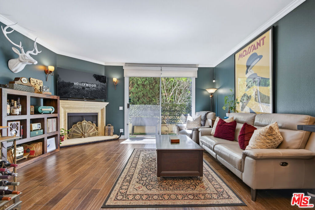 Welcome to this lovely 2-bedroom, 2 & 1/2 bath, townhome-style condo nestled in the heart of Studio City. Tucked away at the rear of the building, this residence offers serene tree-lined views and a peaceful escape from the city buzz. Inside, a thoughtfully designed layout features a warm and inviting living area with a fireplace and private balcony, ideal for relaxing or entertaining. The modern kitchen is a chef's dream, equipped with stainless steel appliances and all the essentials for culinary perfection. Rich hardwood floors and multiple outdoor spaces embrace the quintessential California lifestyle. The spacious primary suite boasts a remodeled en-suite bath, blackout shades, and its own private balcony, while the second bedroom offers a generous sized bathroom with a walk-in shower. A standout feature is the expansive rooftop deck with views of the Burbank mountains and Hollywood Hills perfect for alfresco dining, entertaining, or stargazing under the night sky. Additional amenities include in-unit laundry, side-by-side gated parking, a community pool, and fitness center. Situated within the highly sought-after Carpenter School District and just moments from Studio City's premier dining, shopping, and entertainment, this home perfectly blends comfort, style, and location.