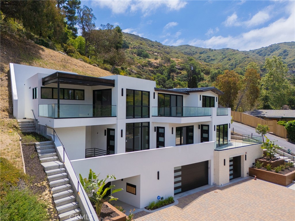 This rare and contemporary Live/Work END UNIT at 20000 Laguna Canyon Rd, Unit C, offers 980 sq ft of premium space designed for creative professionals, entrepreneurs, and corporate executives. Perfect for artists, designers, architects, or companies seeking high-end corporate housing for executive employees. Located on a scenic corner lot in Laguna Canyon, this loft features a FULLY FURNISHED 1 bedroom, 1 full bathroom. Enjoy panoramic hillside views from your open floor plan, black solid cherrywood flooring, sleek glass stair railings, and a fully equipped gourmet kitchen with refrigerator included, plus in-unit washer and dryer. The modern building includes a 2,920 sq ft private garage with 5 parking spaces, 1 handicap stall, 2 motorcycle spots, and EV charging stations. ADA-compliant elevator, ample guest parking, and high-quality finishes throughout. Just minutes to downtown Laguna Beach, hiking/biking trails, art galleries, and the beach. Live, work, and create in style!