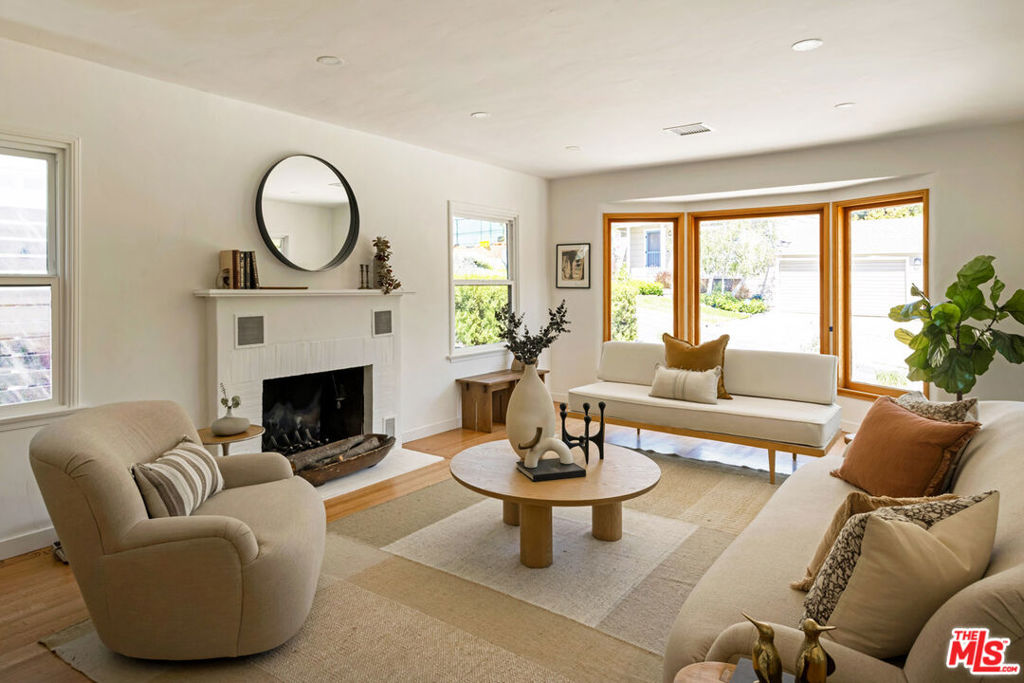 Have it all in prime Eagle Rock with this beautifully renovated Traditional offering a huge yard, bonus space, and a sought-after location. Built in 1949, the home presents an expansive, light-filled layout updated for modern living while retaining period charm, including a gorgeous hearth and bright bay window. Hardwood floors run throughout, and vaulted ceilings set the tone in the open dining and kitchen finished with custom cabinetry, quartz counters, and generous storage. Two upstairs bedrooms include a primary with ensuite bath; the versatile lower-level bonus room is perfect for a den, office, or gym. Glass sliders open to an expansive wraparound deck, your perch for outdoor dining overlooking a park-like backyard with mature trees and space to garden or add a pool. Amenities include AC/heat and an attached garage. Tucked near Pasadena's San Rafael Hills, you're minutes from Found Coffee, Little Flower, and all the energy of nearby Highland Park.