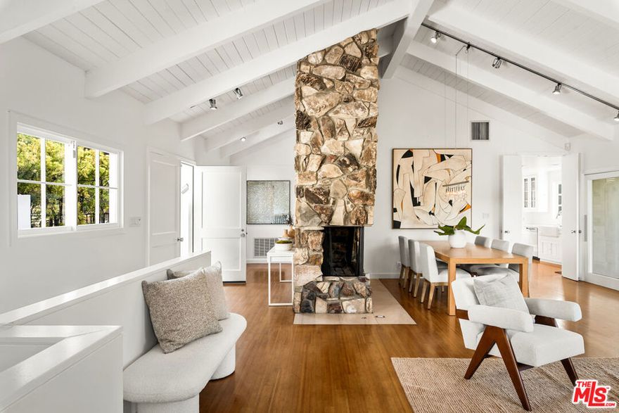 Set in the coveted Nichols Canyon enclave, this 5-bedroom, 3.5-bath, California contemporary offers privacy, character, and sweeping views with a large flat yard and pool.  A discreet gated courtyard opens to double-entry doors and a sunlit great room with soaring beamed ceilings, a stone fireplace, and walls of glass that frame wraparound decks. From here, the views stretch across canyon hillsides to city lights, with the ocean and Catalina Island visible on clear days. The home's versatile two-level layout, with views from nearly every room, lends itself to both quiet retreat and creative work. Off the kitchen, a dining deck sets the stage for meals or conversation with dramatic views as a backdrop. The main floor features two bedrooms, including a serene primary suite with a private deck and direct access to patios below. The lower level adds three bedrooms, two bathrooms, and a generous family room with wood burning fireplace, custom built-ins, and French doors that connect to the expansive flat, sun-drenched lawn, bordered by mature Sycamore and fruit trees. A solar-heated pool with Saltillo-tiled deck anchors the outdoor space, and offers a private setting to gather, entertain, or unwind. With multiple decks, a flexible floor plan, and a peaceful natural setting, this exceptionally private home captures the essence of Los Angeles indoor-outdoor living just minutes from Runyon Canyon, West Hollywood, Beverly Hills, and the Valley.