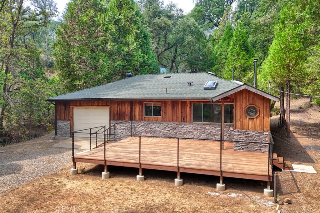 Turn key home with all the mountain charm! Located at about the 3700 foot elevation in Mariposa Pines where the pine trees tower, summers are cooler and snow can be enjoyed in the winter, this Craftsman Style home is perfect for your family! The home is hidden way back from the road on this very level lot offering plenty of privacy and room for activities. Entertainment begins on the brand new massive front deck and continues, in cooler weather, to the insulated garage with ceiling fan heaters. A mudroom is a must for mountain life and this one is so charming with the octagon shaped window, jacket hooks on the wall and a bench for removing boots. The living space is inviting and open with large windows and skylights in every room. This comfortable home has been lovingly maintained, recent updates include a roof installed circa 2018, fully remodeled primary bathroom, new tankless water heater and brand new carpet in every room. Enjoy the back patio privacy and the quiet sounds of a seasonal creek plus bird song with views of the meadow beyond. Here you will also enjoy fruits of the land, homegrown apples, pears and blackberries for your nourishment. Fresh mountain air and easy access to National Forest awaits you in lovely Mariposa Pines!