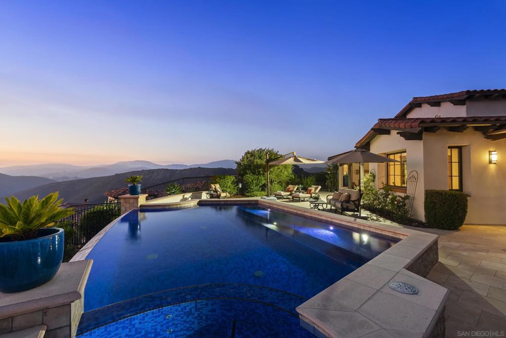 A chic & modern villa of boutique elegance and artful design. Perched atop a serene and private hillside in the prestigious guard-gated community of Cielo, this timeless Santa Barbara-style villa offers resort-style living at its finest. From the moment you step into the enchanting entry courtyard—complete with a cozy fireplace—you’re welcomed into a world of refined comfort and effortless indoor-outdoor living. This custom inspired villa showcases a spacious open-concept design that is as tasteful as it is inviting. At the heart of the home, a chef’s kitchen with a grand center island flows effortlessly into a sunlit breakfast nook and an expansive great room, creating the perfect setting for both everyday living and effortless entertaining. Thoughtfully designed for connection and comfort, the seamless layout blends timeless architecture with a warm, welcoming ambiance. The private quarters are designed for serenity and comfort. The primary suite serves as a true retreat, offering serene views, and a spa-inspired ambiance. A spacious secondary bedroom within the main residence also enjoys beautiful vistas, thoughtfully positioned away from the main living areas. The boutique-style attached casita provides a separate space for guests or a private home office, blending style with versatility. Showcasing breathtaking panoramic views that stretch in every direction from every room of the property. This custom inspired villa was designed to embrace San Diego’s coveted lifestyle, the expansive great room flows seamlessly to a covered outdoor loggia with a fireplace—ideal for... This custom inspired villa showcases a spacious open-concept design that is as tasteful as it is inviting. At the heart of the home, a chef’s kitchen with a grand center island flows effortlessly into a sunlit breakfast nook and an expansive great room, creating the perfect setting for both everyday living and effortless entertaining. Thoughtfully designed for connection and comfort, the seamless layout blends timeless architecture with a warm, welcoming ambiance. The private quarters are designed for serenity and comfort. The primary suite serves as a true retreat, offering serene views, and a spa-inspired ambiance. A spacious secondary bedroom within the main residence also enjoys beautiful vistas, thoughtfully positioned away from the main living areas. The boutique-style attached casita provides a separate space for guests or a private home office, blending style with versatility. Showcasing breathtaking panoramic views that stretch in every direction from every room of the property. This custom inspired villa was designed to embrace San Diego’s coveted lifestyle, the expansive great room flows seamlessly to a covered outdoor loggia with a fireplace—ideal for al fresco dining or savoring golden sunsets. An architectural masterpiece, the home centers around a stunning infinity-edge pool and spa that visually spill into the horizon, creating a tranquil oasis of calm and luxury. Whether you're entertaining guests or enjoying a quiet evening at home, every space is thoughtfully designed to maximize natural beauty and privacy. Cielo in Rancho Santa Fe offers a vibrant, luxury lifestyle. Enjoy a full calendar of social activities - plus exceptional amenities including a community center, gym, clubhouse, tennis and pickleball courts, playgrounds, multiple pools, and courts for basketball and volleyball, all included with the HOA. This property is located in Rancho Santa Fe School District - Roger Rowe Don’t miss this rare opportunity to own a sanctuary where every detail is curated for peace, privacy, and panoramic perfection.