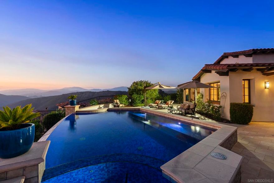 A chic & modern villa of boutique elegance and artful design. Perched atop a serene and private hillside in the prestigious guard-gated community of Cielo, this timeless Santa Barbara-style villa offers resort-style living at its finest. From the moment you step into the enchanting entry courtyard—complete with a cozy fireplace—you’re welcomed into a world of refined comfort and effortless indoor-outdoor living. This custom inspired villa showcases a spacious open-concept design that is as tasteful as it is inviting. At the heart of the home, a chef’s kitchen with a grand center island flows effortlessly into a sunlit breakfast nook and an expansive great room, creating the perfect setting for both everyday living and effortless entertaining. Thoughtfully designed for connection and comfort, the seamless layout blends timeless architecture with a warm, welcoming ambiance. The private quarters are designed for serenity and comfort. The primary suite serves as a true retreat, offering serene views, and a spa-inspired ambiance. A spacious secondary bedroom within the main residence also enjoys beautiful vistas, thoughtfully positioned away from the main living areas. The boutique-style attached casita provides a separate space for guests or a private home office, blending style with versatility. Showcasing breathtaking panoramic views that stretch in every direction from every room of the property. This custom inspired villa was designed to embrace San Diego’s coveted lifestyle, the expansive great room flows seamlessly to a covered outdoor loggia with a fireplace—ideal for...  This custom inspired villa showcases a spacious open-concept design that is as tasteful as it is inviting. At the heart of the home, a chef’s kitchen with a grand center island flows effortlessly into a sunlit breakfast nook and an expansive great room, creating the perfect setting for both everyday living and effortless entertaining. Thoughtfully designed for connection and comfort, the seamless layout blends timeless architecture with a warm, welcoming ambiance.  The private quarters are designed for serenity and comfort. The primary suite serves as a true retreat, offering serene views, and a spa-inspired ambiance. A spacious secondary bedroom within the main residence also enjoys beautiful vistas, thoughtfully positioned away from the main living areas. The boutique-style attached casita provides a separate space for guests or a private home office, blending style with versatility.  Showcasing breathtaking panoramic views that stretch in every direction from every room of the property. This custom inspired villa was designed to embrace San Diego’s coveted lifestyle, the expansive great room flows seamlessly to a covered outdoor loggia with a fireplace—ideal for al fresco dining or savoring golden sunsets.  An architectural masterpiece, the home centers around a stunning infinity-edge pool and spa that visually spill into the horizon, creating a tranquil oasis of calm and luxury. Whether you're entertaining guests or enjoying a quiet evening at home, every space is thoughtfully designed to maximize natural beauty and privacy.  Cielo in Rancho Santa Fe offers a vibrant, luxury lifestyle. Enjoy a full calendar of social activities - plus exceptional amenities including a community center, gym, clubhouse, tennis and pickleball courts, playgrounds, multiple pools, and courts for basketball and volleyball, all included with the HOA. This property is located in Rancho Santa Fe School District - Roger Rowe  Don’t miss this rare opportunity to own a sanctuary where every detail is curated for peace, privacy, and panoramic perfection.